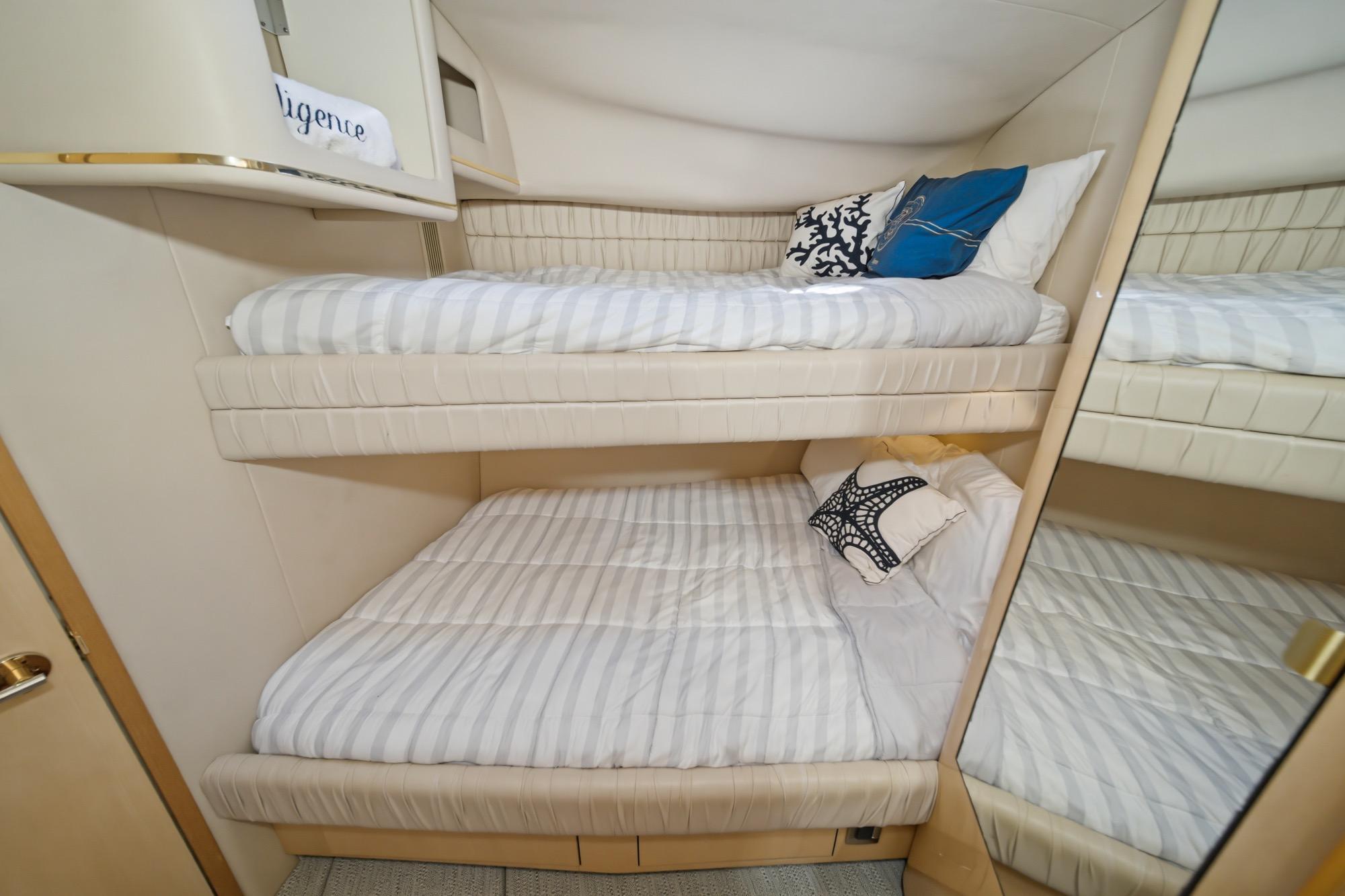 1999 Sea Ray 500 Sundancer cabin with bunk beds and decorative pillows.