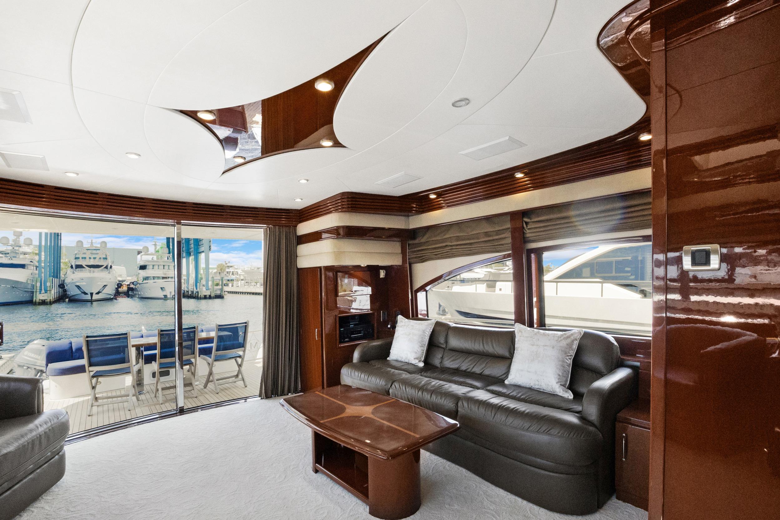 Luxurious interior of 2008 Marquis 690 yacht with leather seating and marina view.