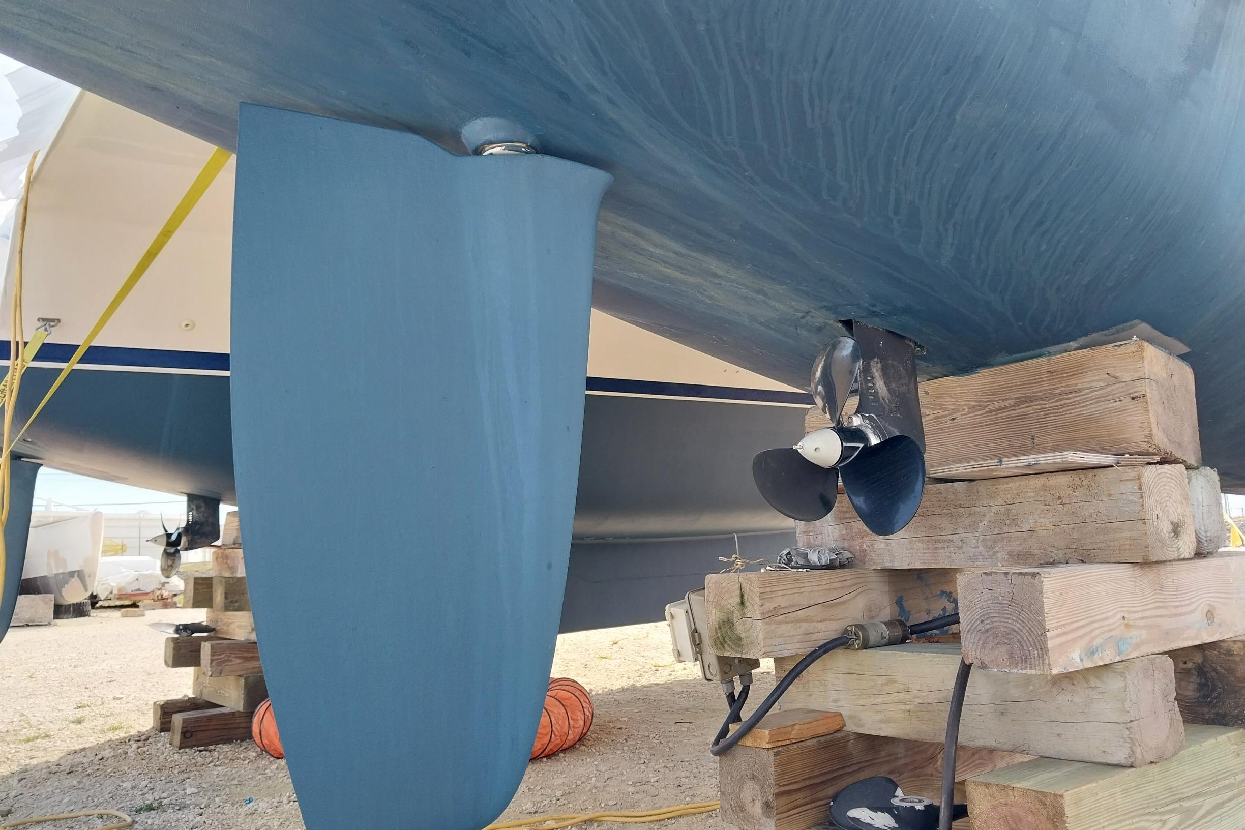 Underwater view of a 2020 Leopard 45 catamaran's propeller and rudder on wooden blocks.
