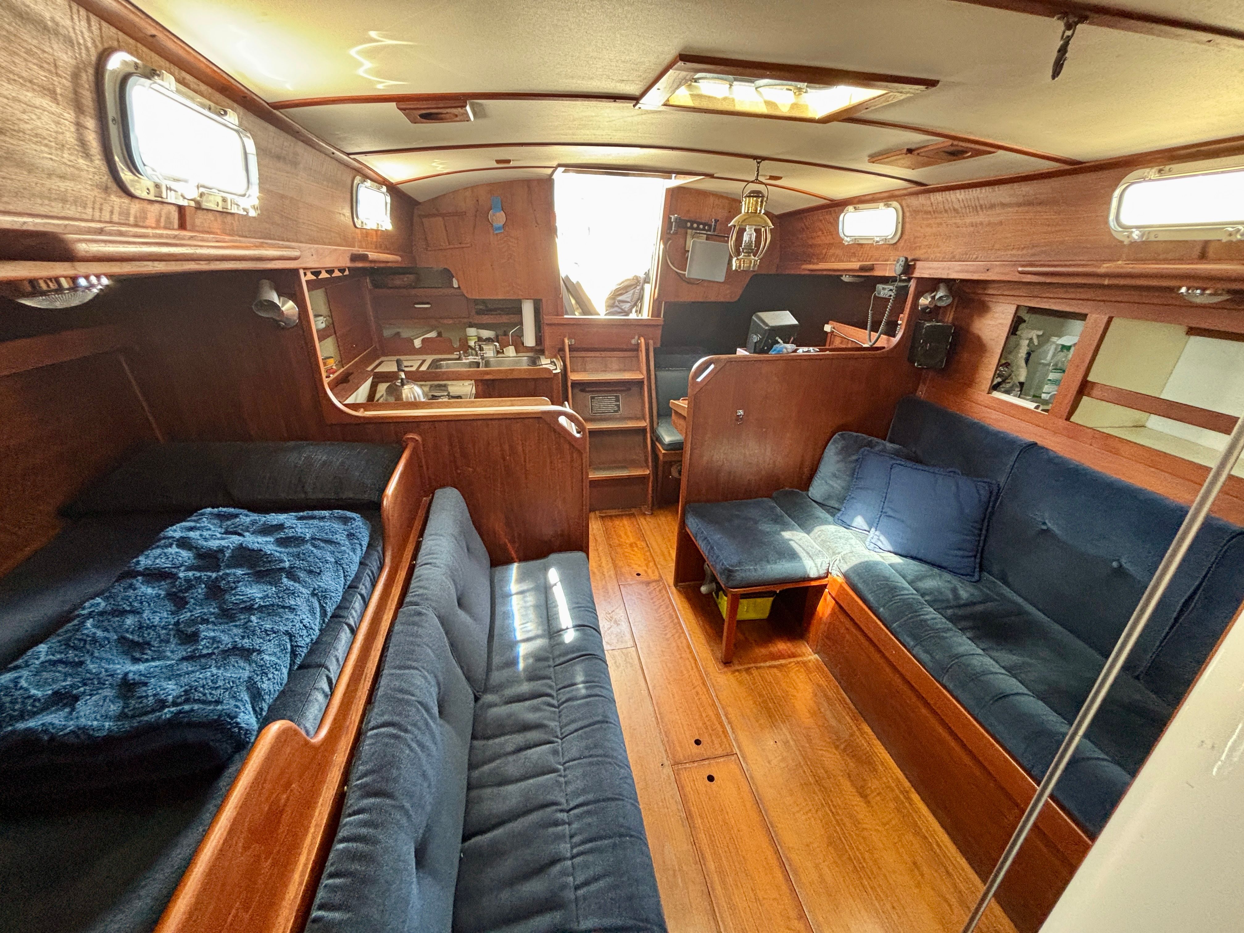 Interior of a 1979 Tartan 37 with wood finish and blue upholstery.