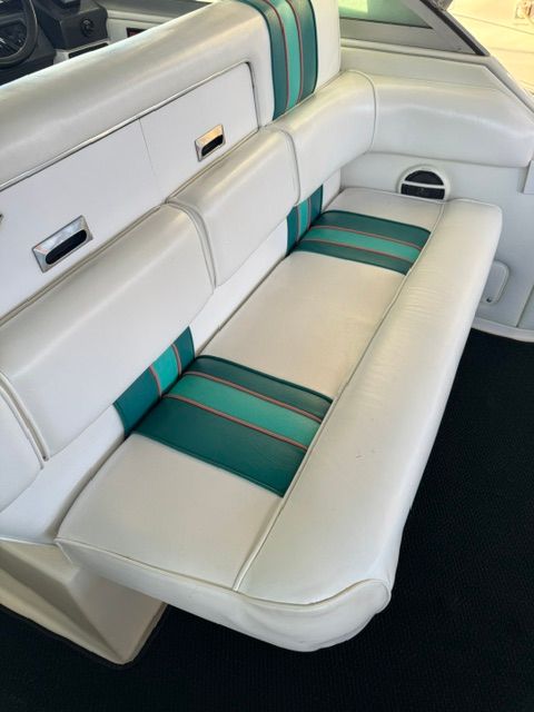 Interior of a 1992 Sea Ray 290 Sundancer with white and green upholstered seating.