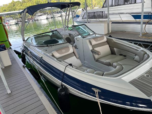 2019 Crownline E255 boat docked, featuring sleek design and spacious seating.