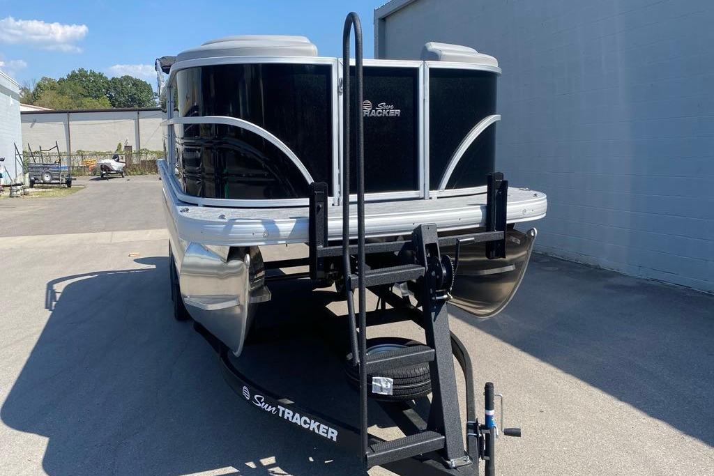 2026 Sun Tracker Party Barge 22 DLX pontoon boat on trailer, parked outdoors.