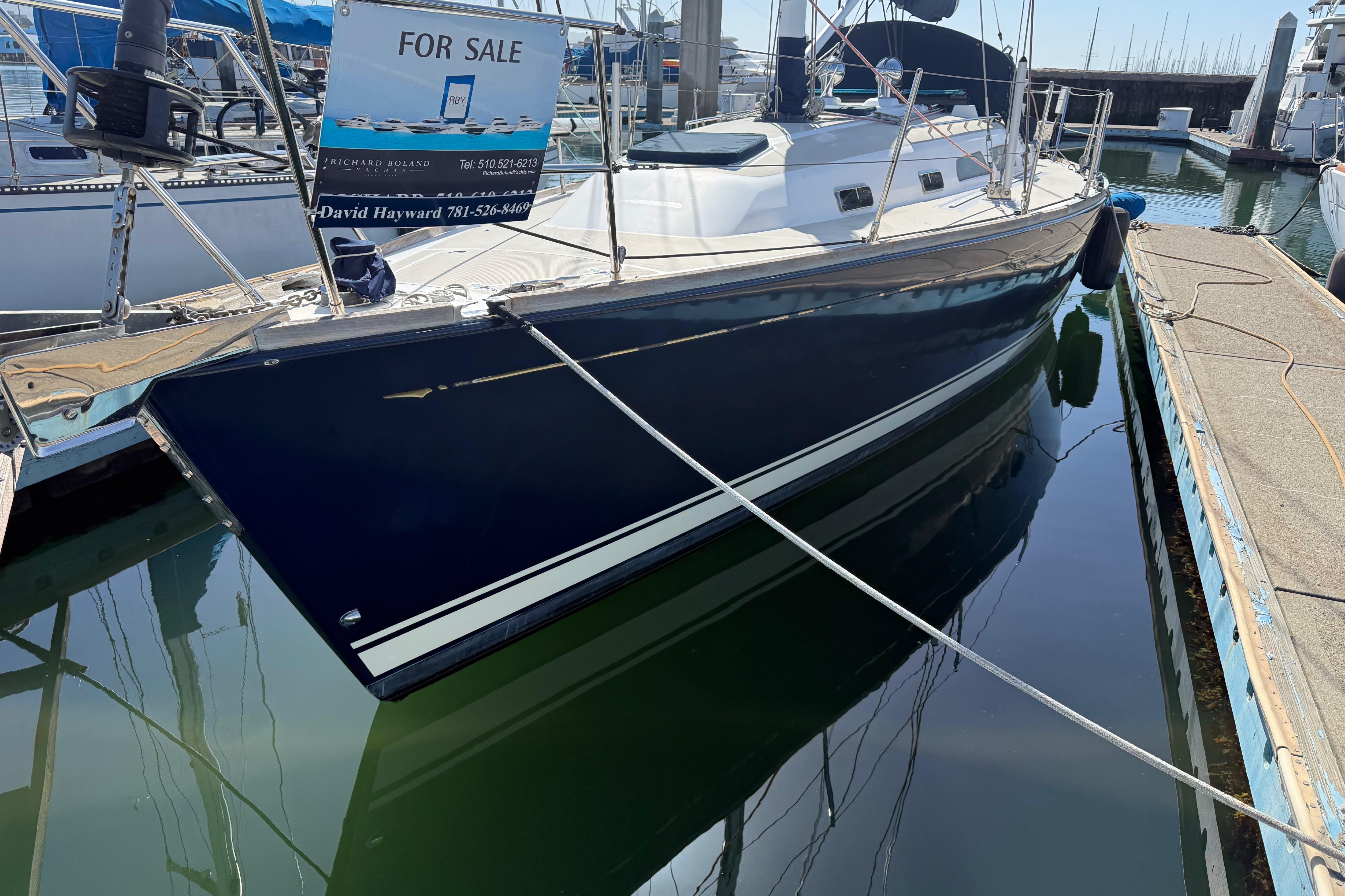 2004 Sabre 386 sailboat for sale, docked at marina, blue hull, white deck.