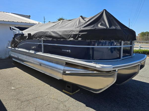 2025 Harris Cruiser 230 pontoon boat with cover, parked outdoors.