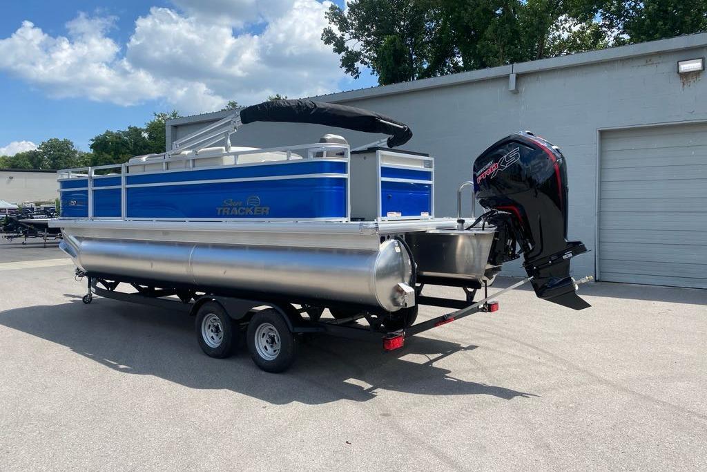 2026 Sun Tracker Fishin' Barge 20 DLX pontoon boat on trailer, outdoors.
