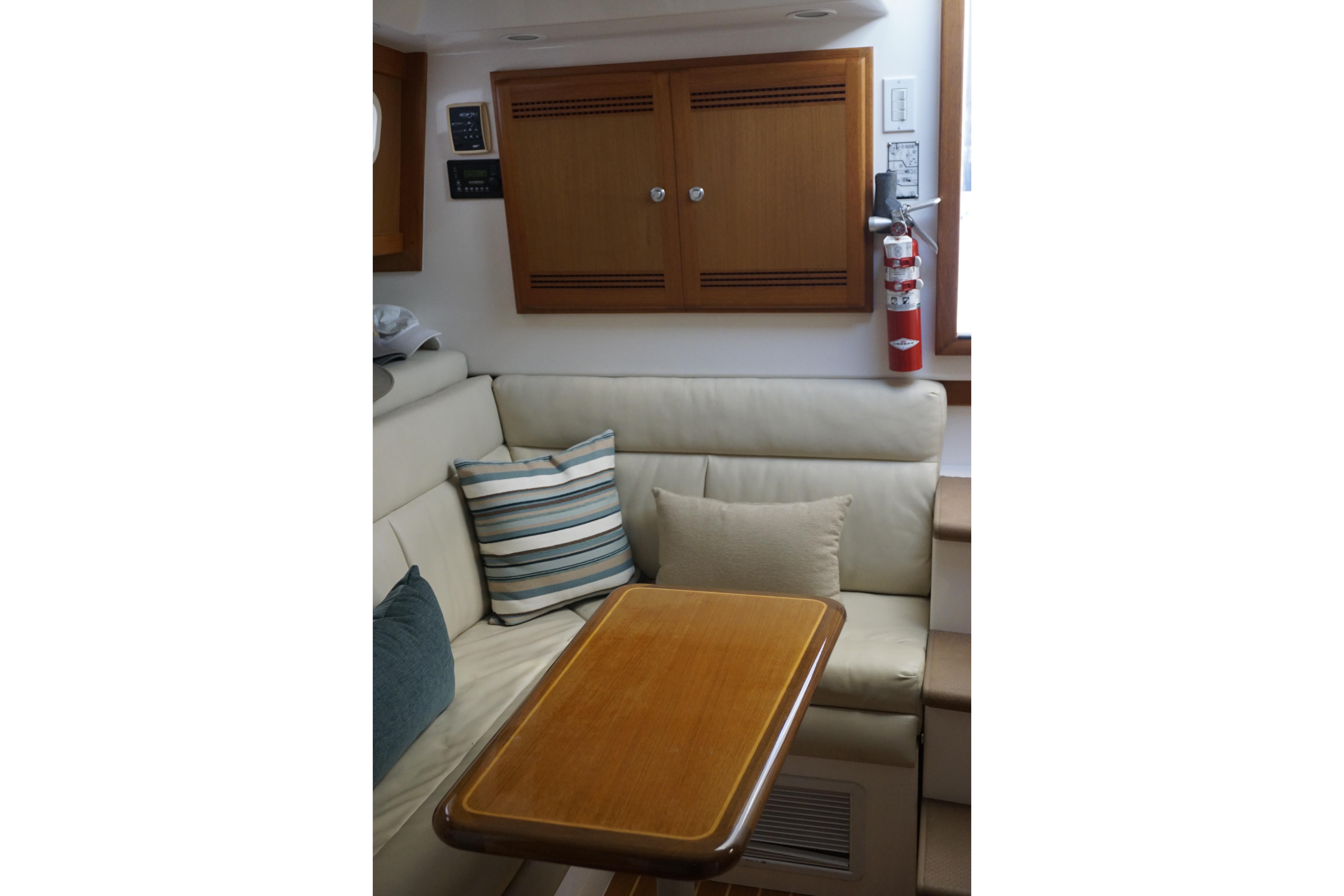Interior of 2005 Cabo 35 Express yacht with cozy seating and wooden table.