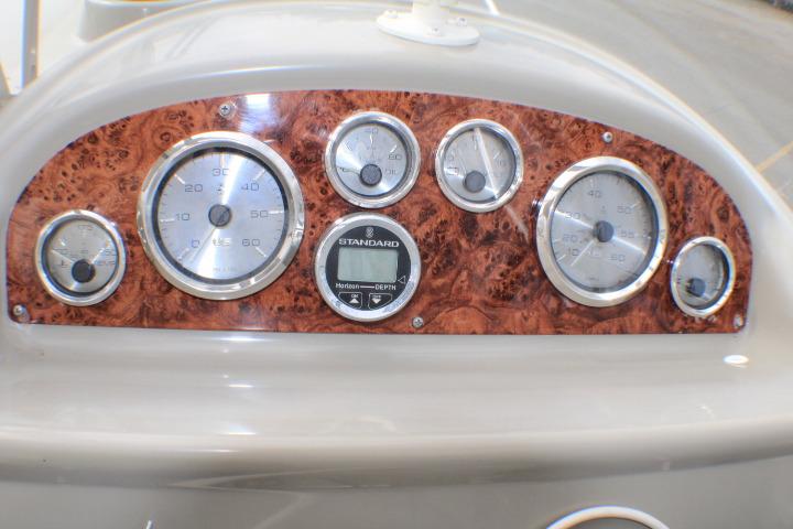 Dashboard of a 1998 Bayliner 2655 Ciera Sunbridge with wood paneling and gauges.