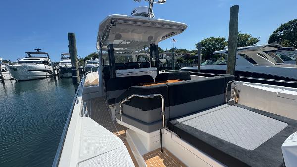 2025 Nimbus T11 boat docked, featuring sleek design and spacious seating area.