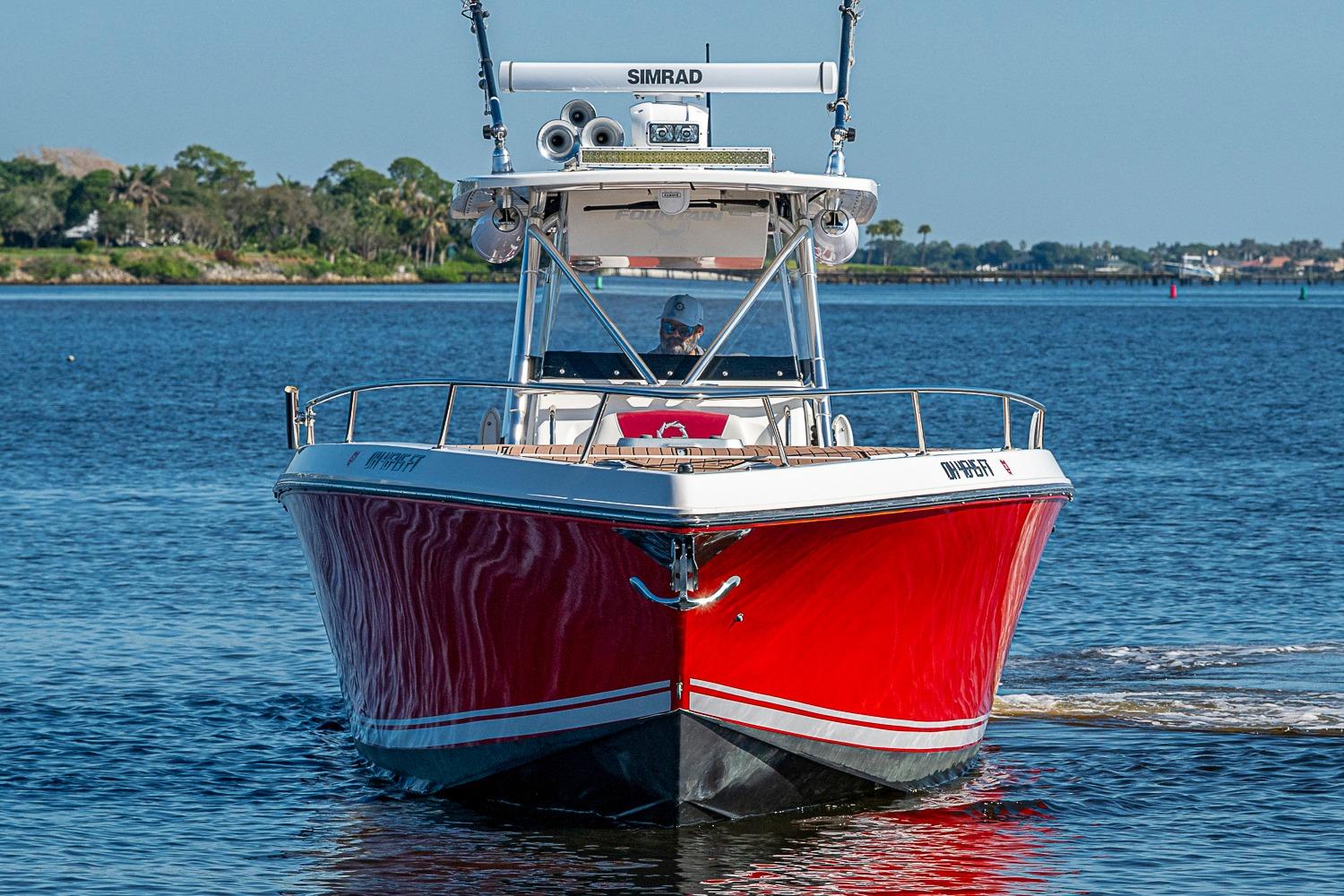 2009 Fountain 38 Center Console boat with red hull on calm water.