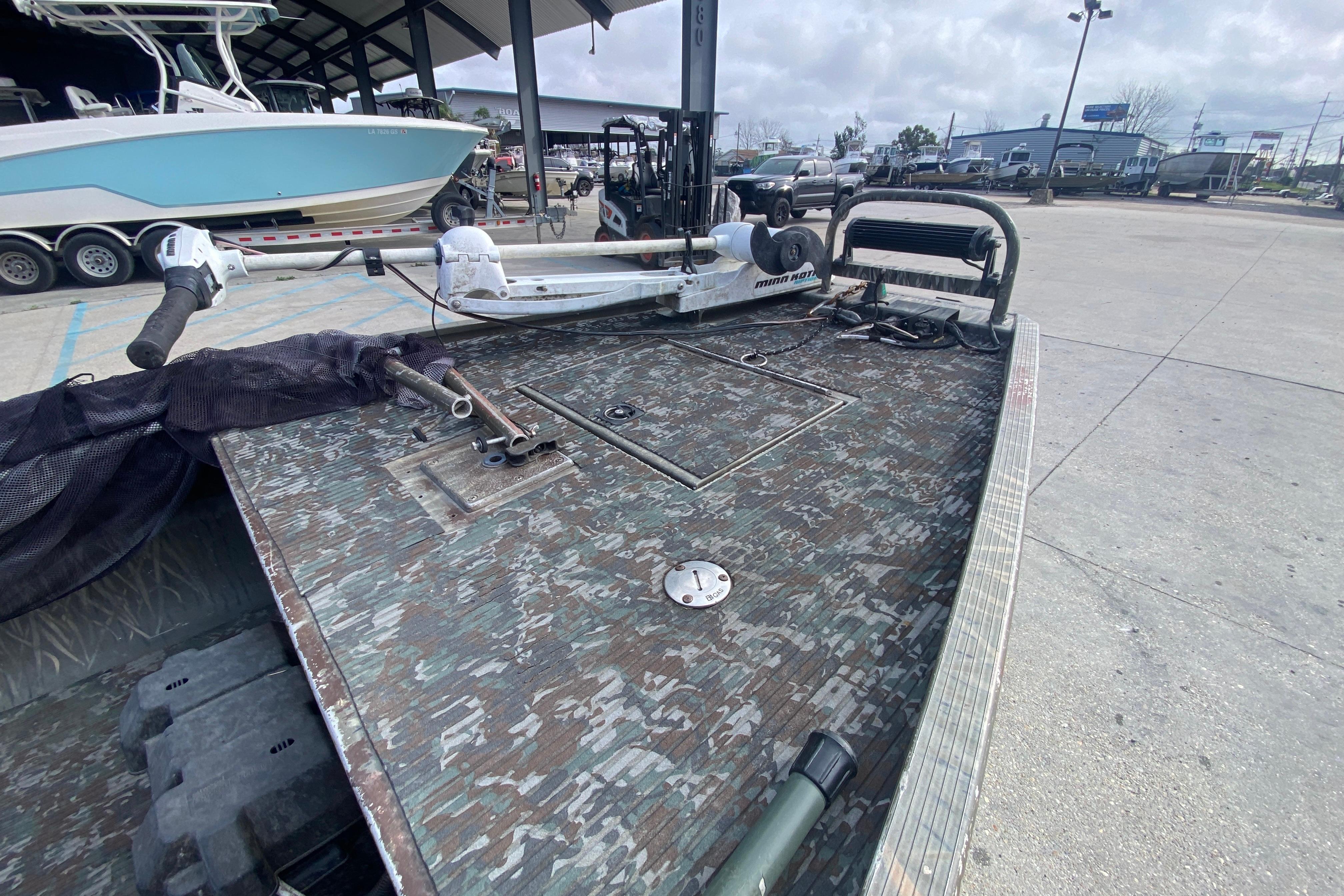 2009 Gator Trax MUD BUDDY boat with camo deck, parked outdoors.