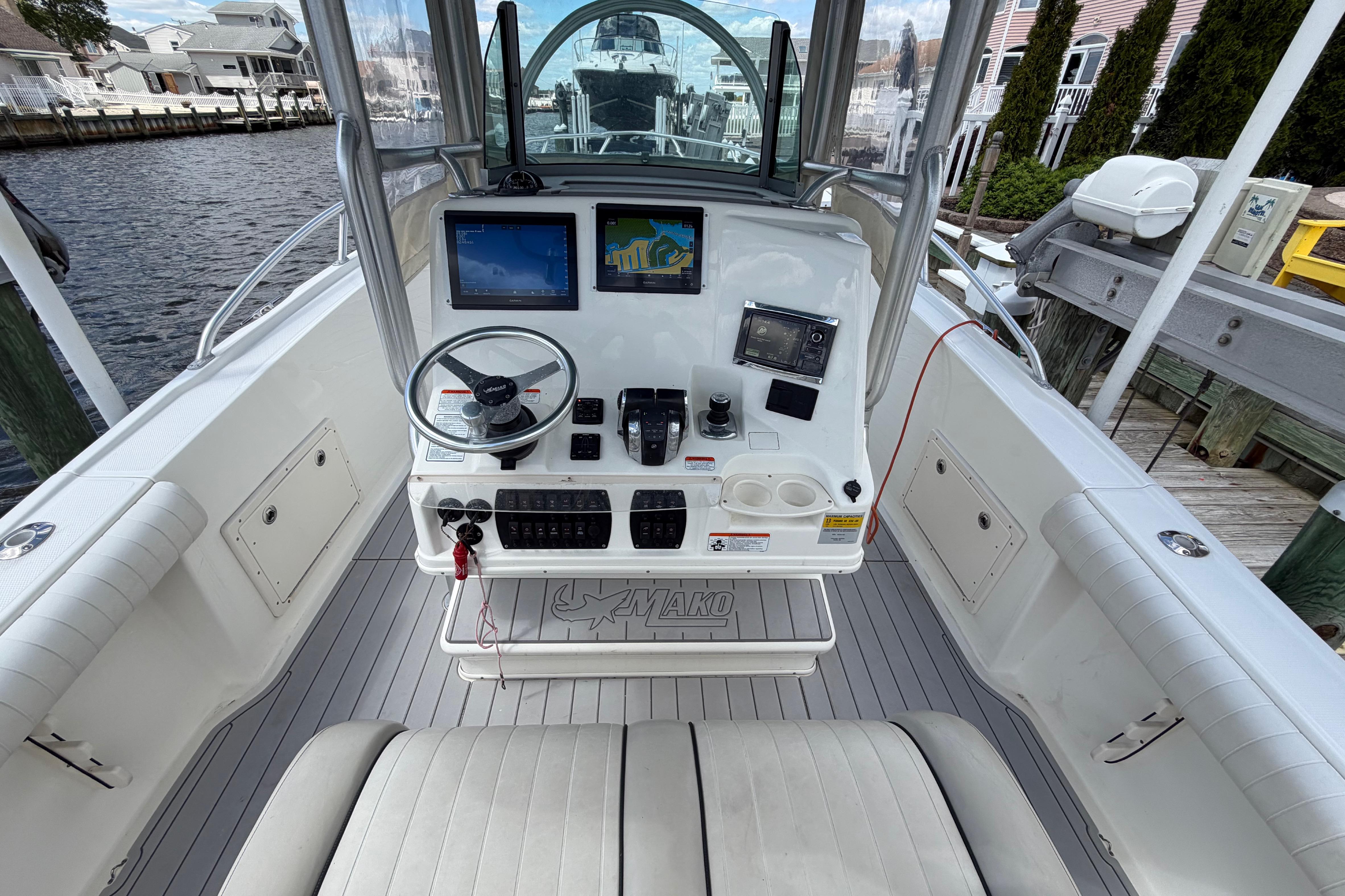 2017 Mako 284 Center Console boat interior with navigation equipment and steering wheel.