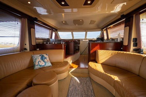 Luxurious interior of 2006 Sea Ray 580 Sedan Bridge yacht with elegant seating and panoramic windows.