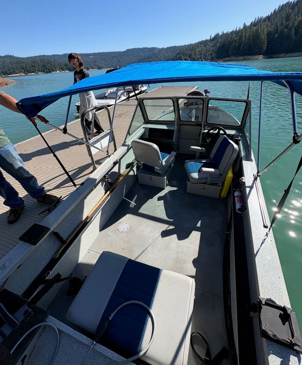 A 2002 Stryker Rogue boat docked. It features a blue sunshade and seating area.
