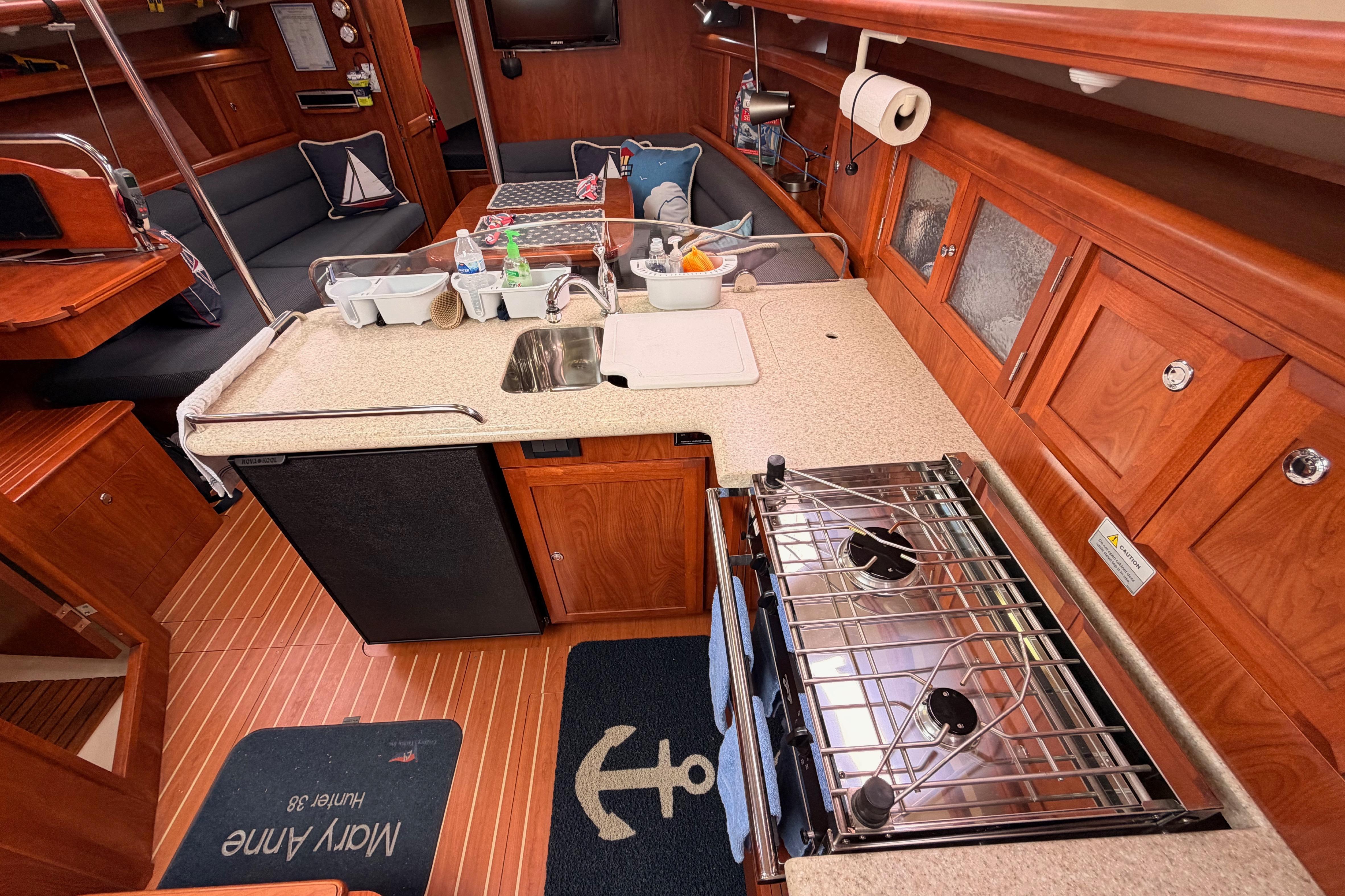 Interior of 2009 Hunter 38 sailboat featuring a compact kitchen with stove and sink.