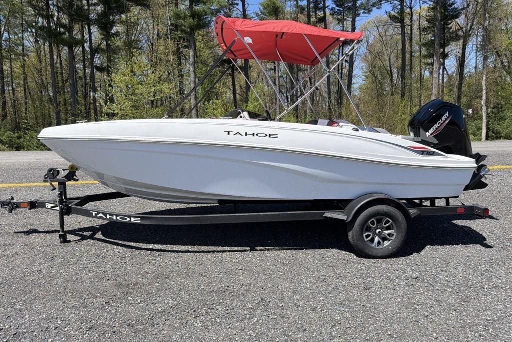 2026 Tahoe T18 boat with red canopy on trailer, parked on gravel road.