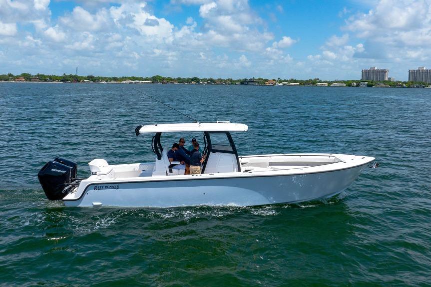 2027 Reef Runner 340 boat cruising on a sunny day with passengers onboard.