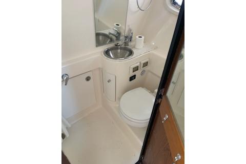 2013 Tiara Yachts 3100 Open bathroom with sink, toilet, and mirror.
