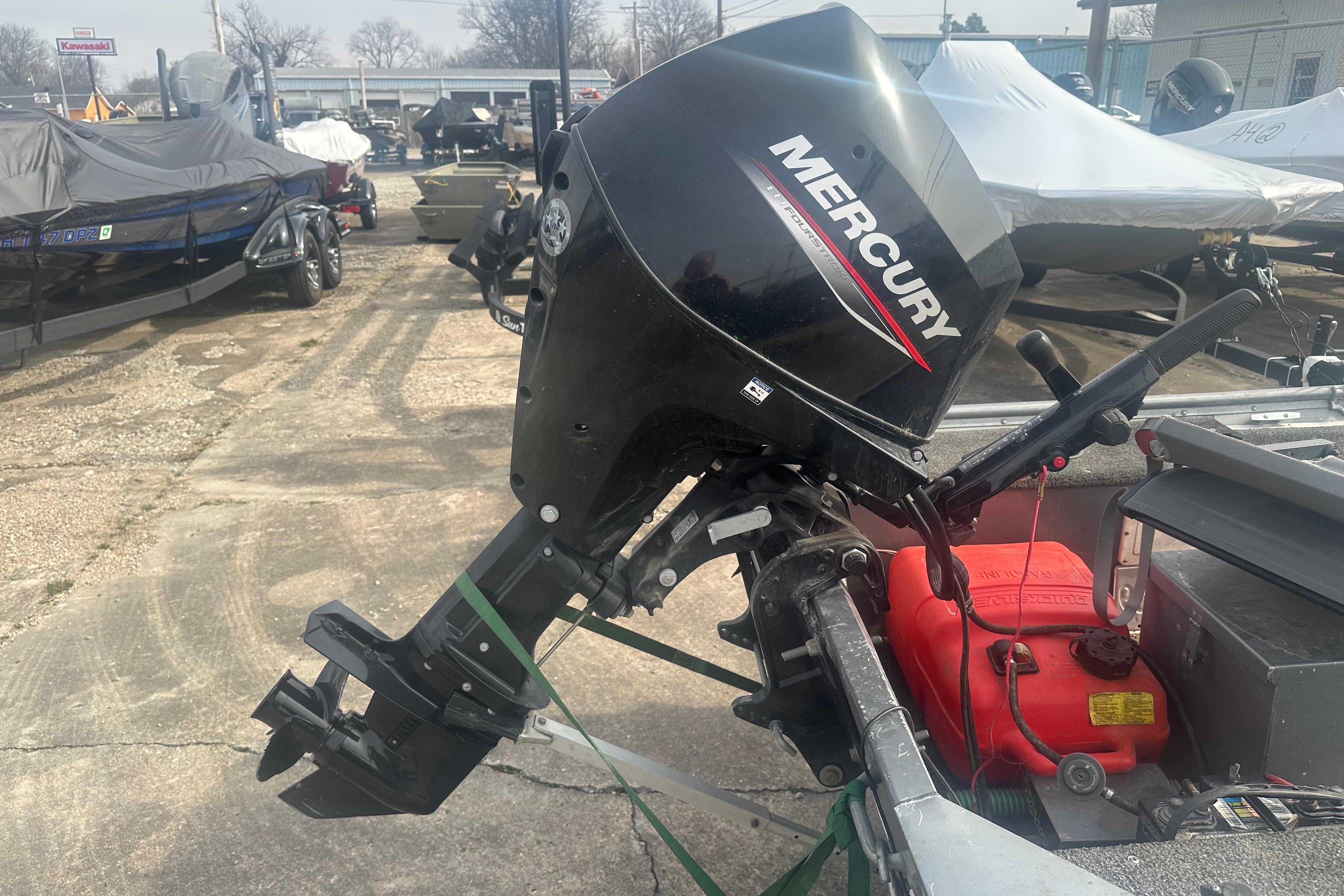 Mercury outboard motor on 1991 Grumman Rogue 150 T boat, parked in a marina.