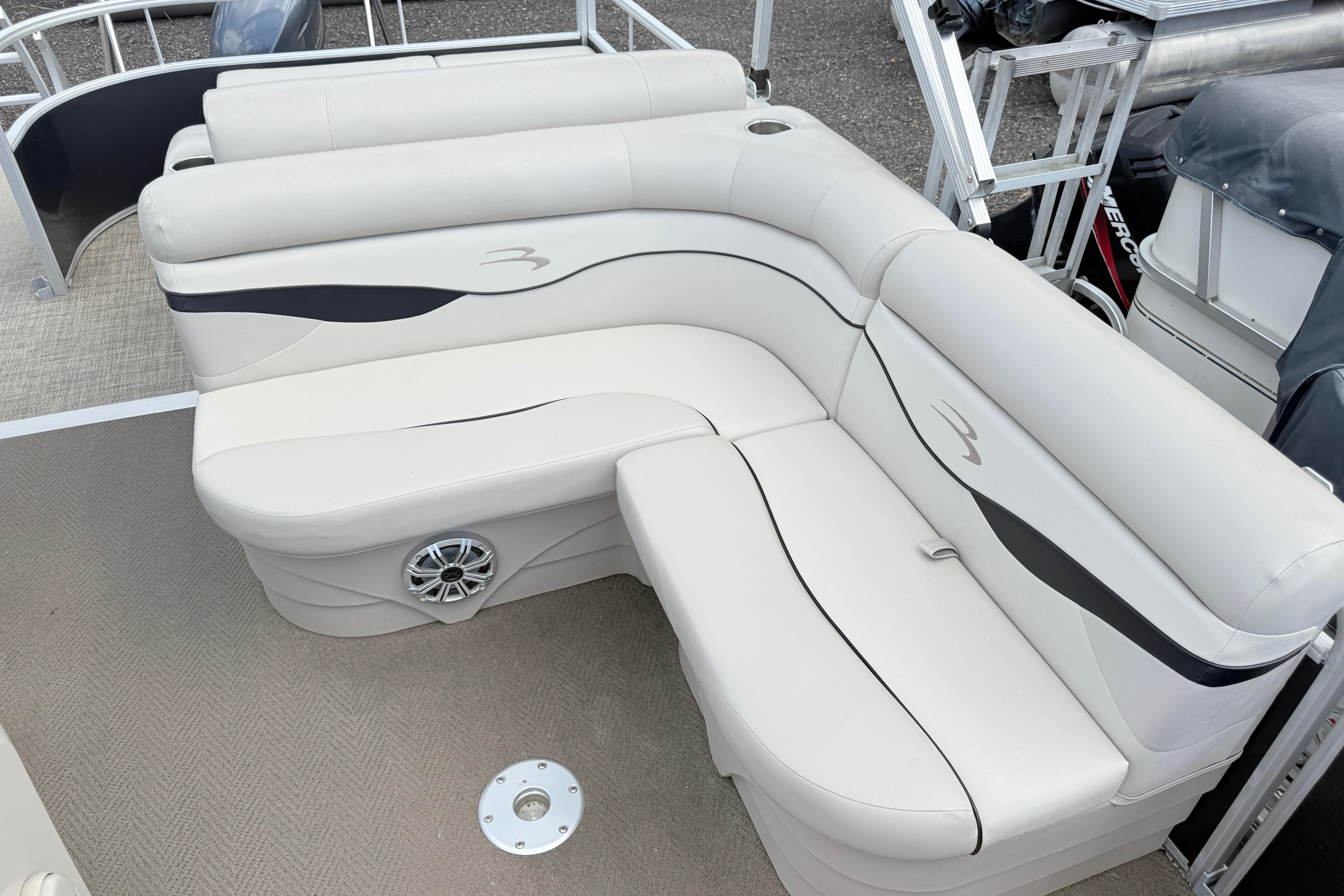 2015 Bennington 24SSLX pontoon boat with white cushioned seating and speaker detail.