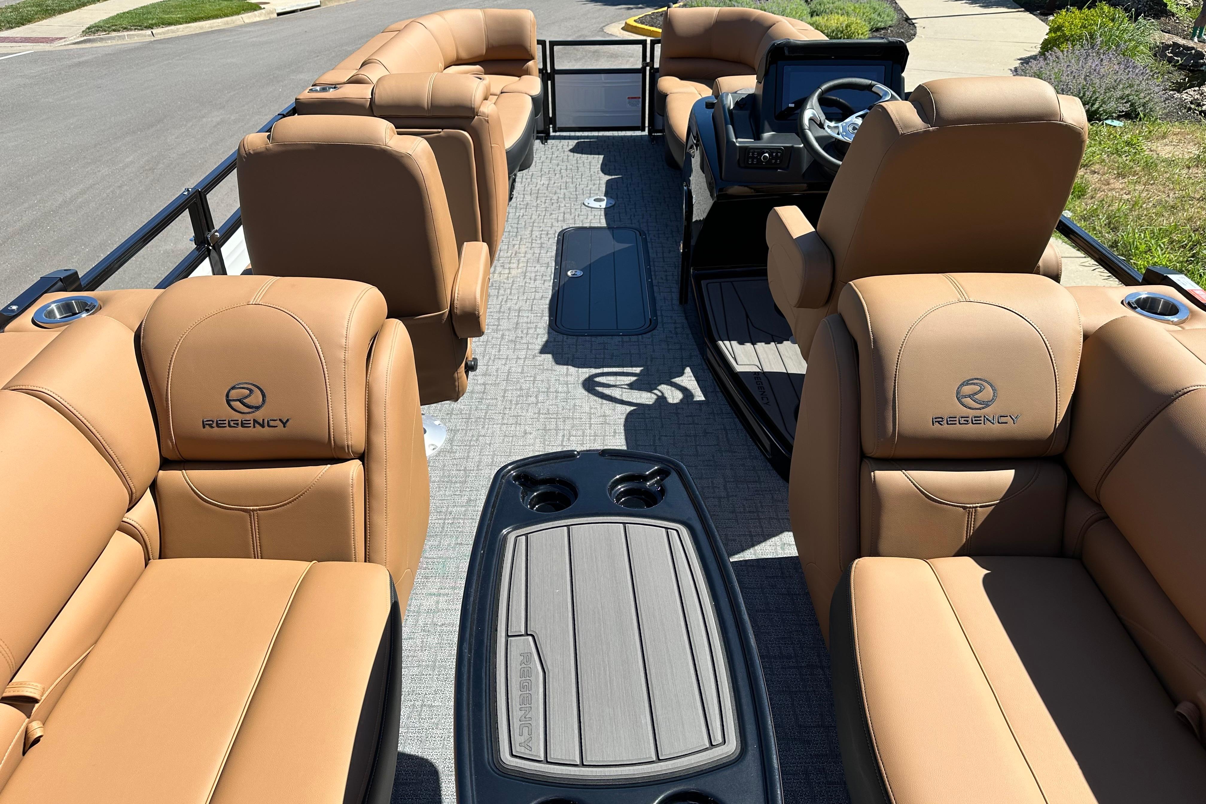 Luxurious 2026 Regency 230 DL pontoon boat with tan leather seating and modern dashboard.