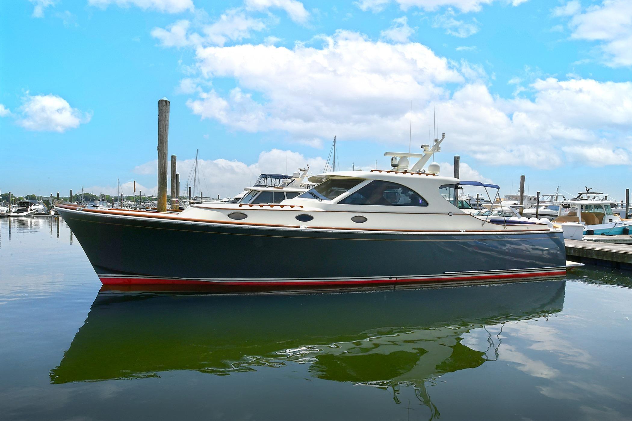 2005 San Juan Downeast Express yacht docked in a marina under a blue sky.
