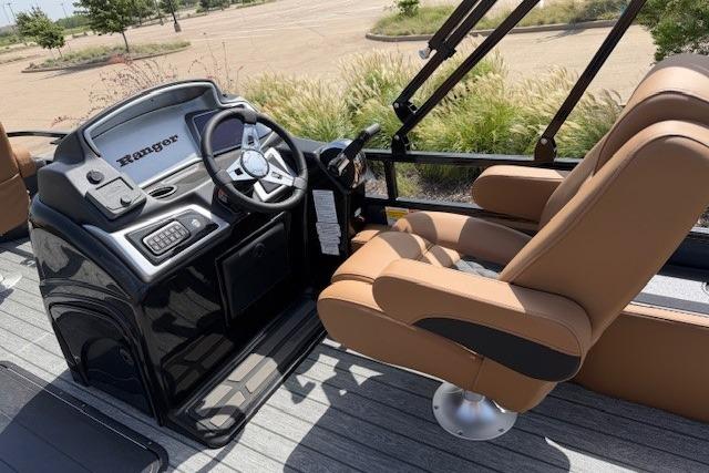 Captain's seat and console of 2026 Ranger 223F boat, featuring modern controls and tan upholstery.