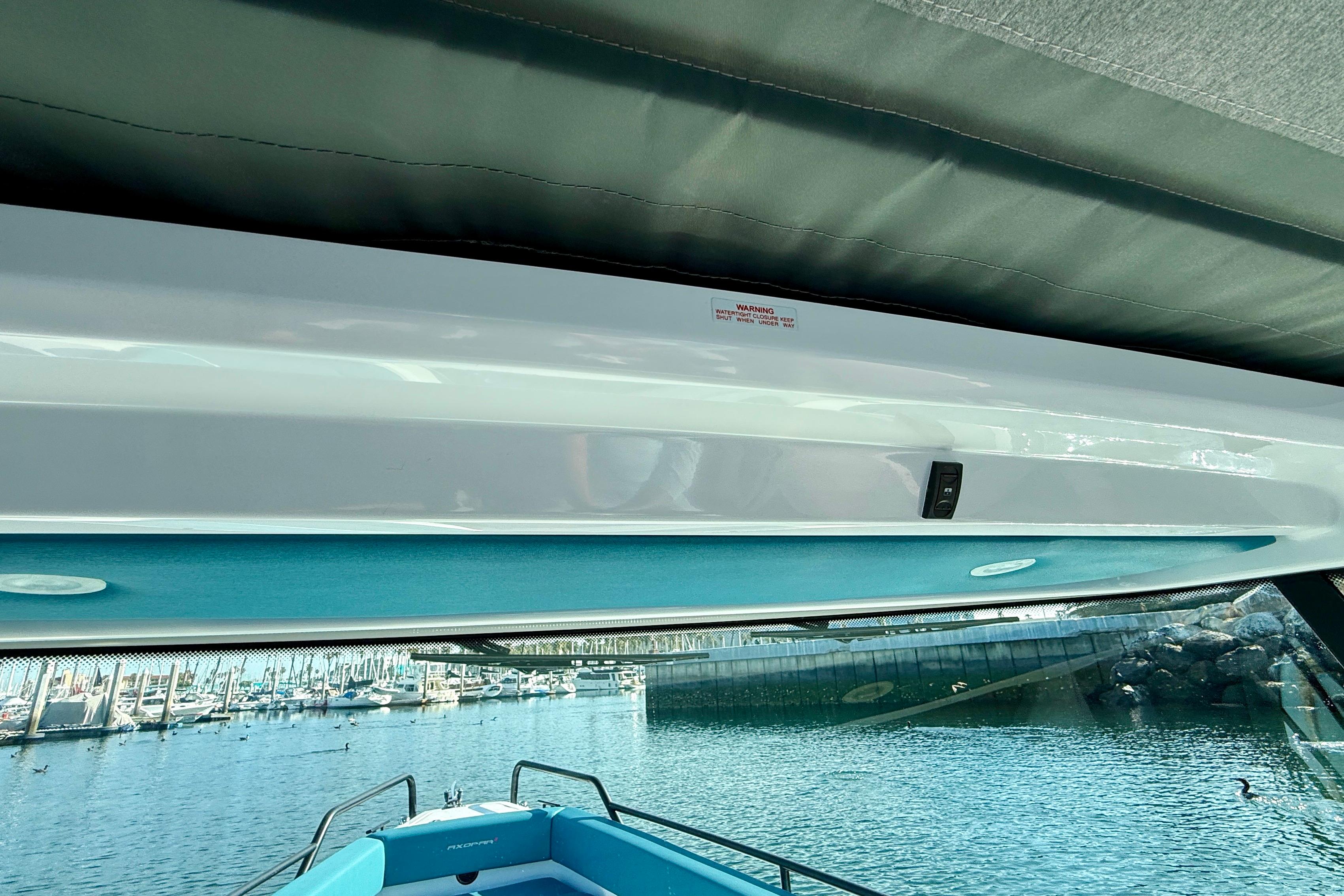 Interior view of 2021 Axopar Brabus 28 Cabin boat with marina background.