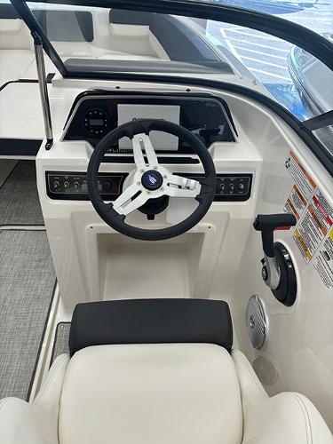 2024 Bayliner DX 2050 boat cockpit with steering wheel and control panel.