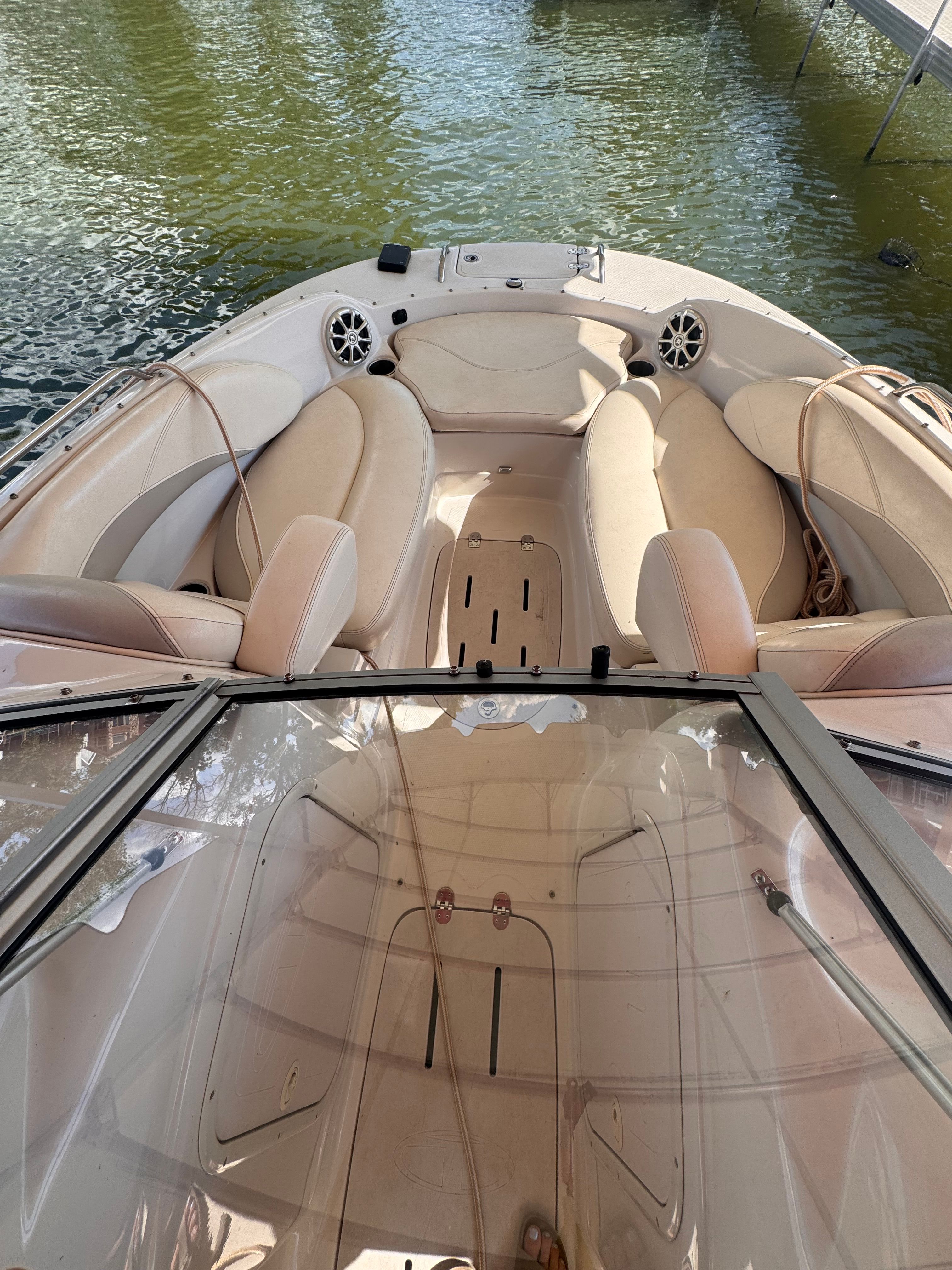 The image shows the cockpit of a 2011 Tahoe 228 boat with beige seating and speakers.