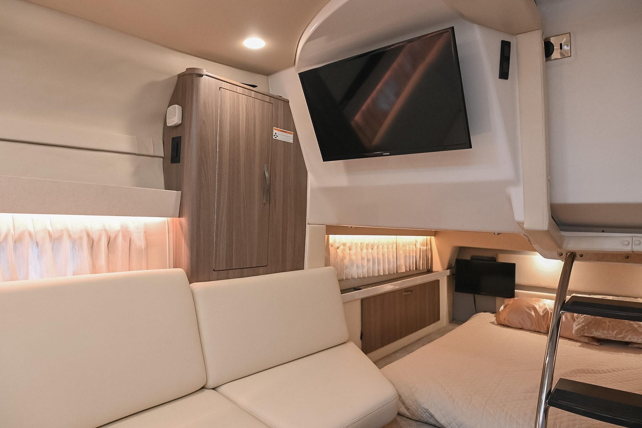 Interior of 2021 Regal 33 Express yacht with modern furnishings and mounted TV.