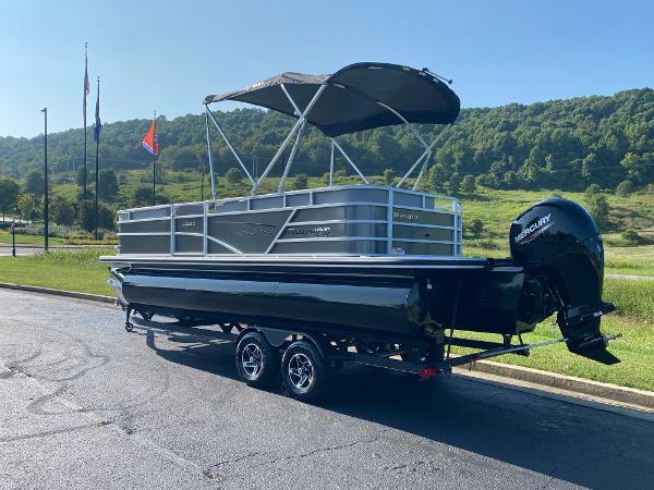 2024 Ranger Reata 223C pontoon boat with canopy on trailer, scenic background.