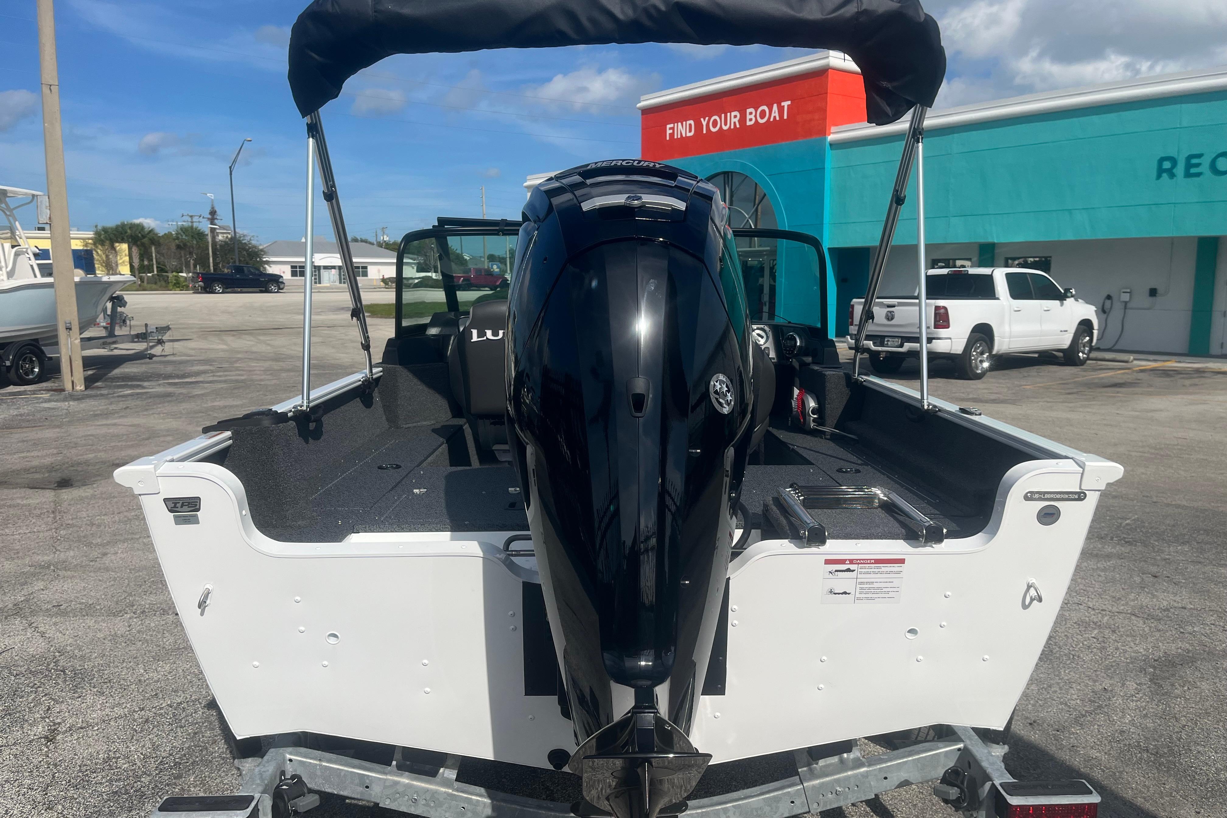 2026 Lund 1650 Rebel XL Sport boat with outboard motor, parked outdoors.