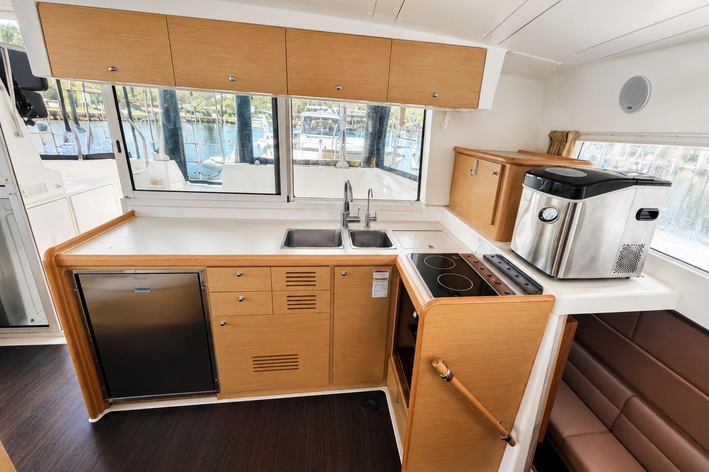 Interior of the 2010 Lagoon 421 with modern kitchen and harbor view.