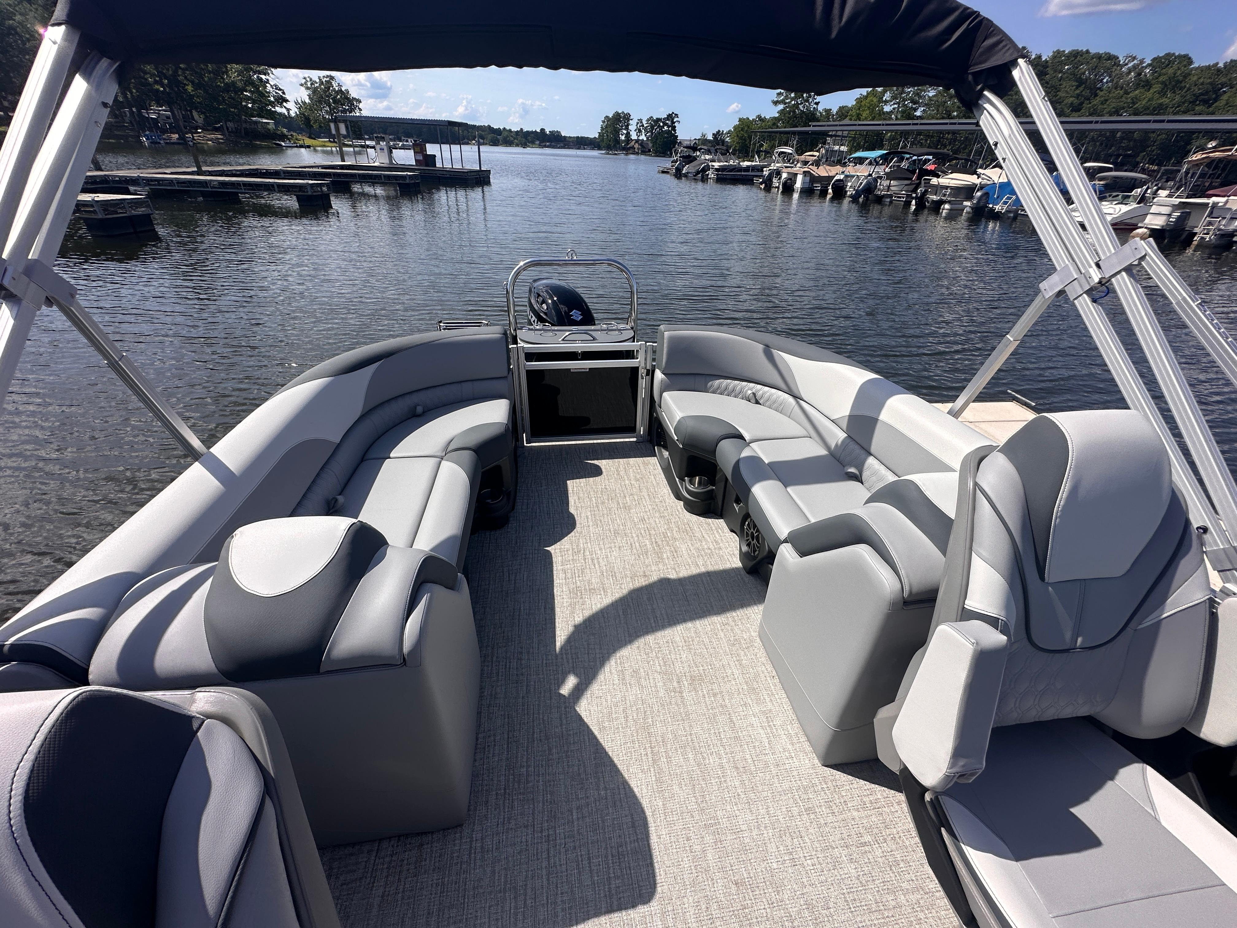 2025 Avalon LSZ Quad Lounger pontoon boat with spacious seating on a serene lake.