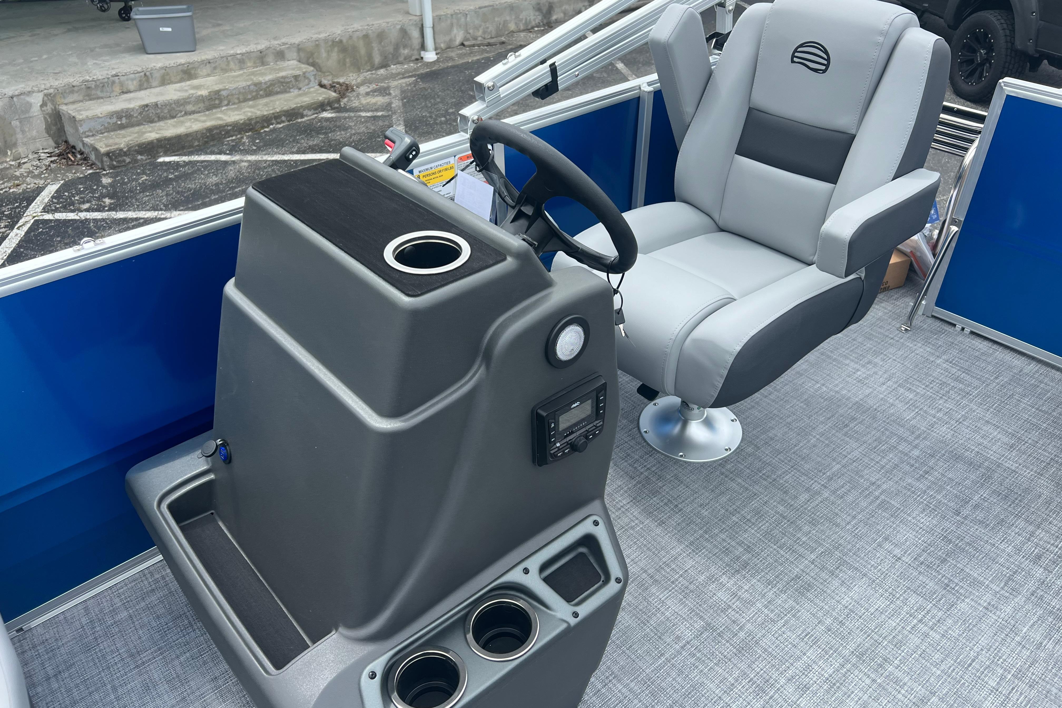 Interior of 2026 Sun Tracker Party Barge 16 DLX with captain's chair and control console.