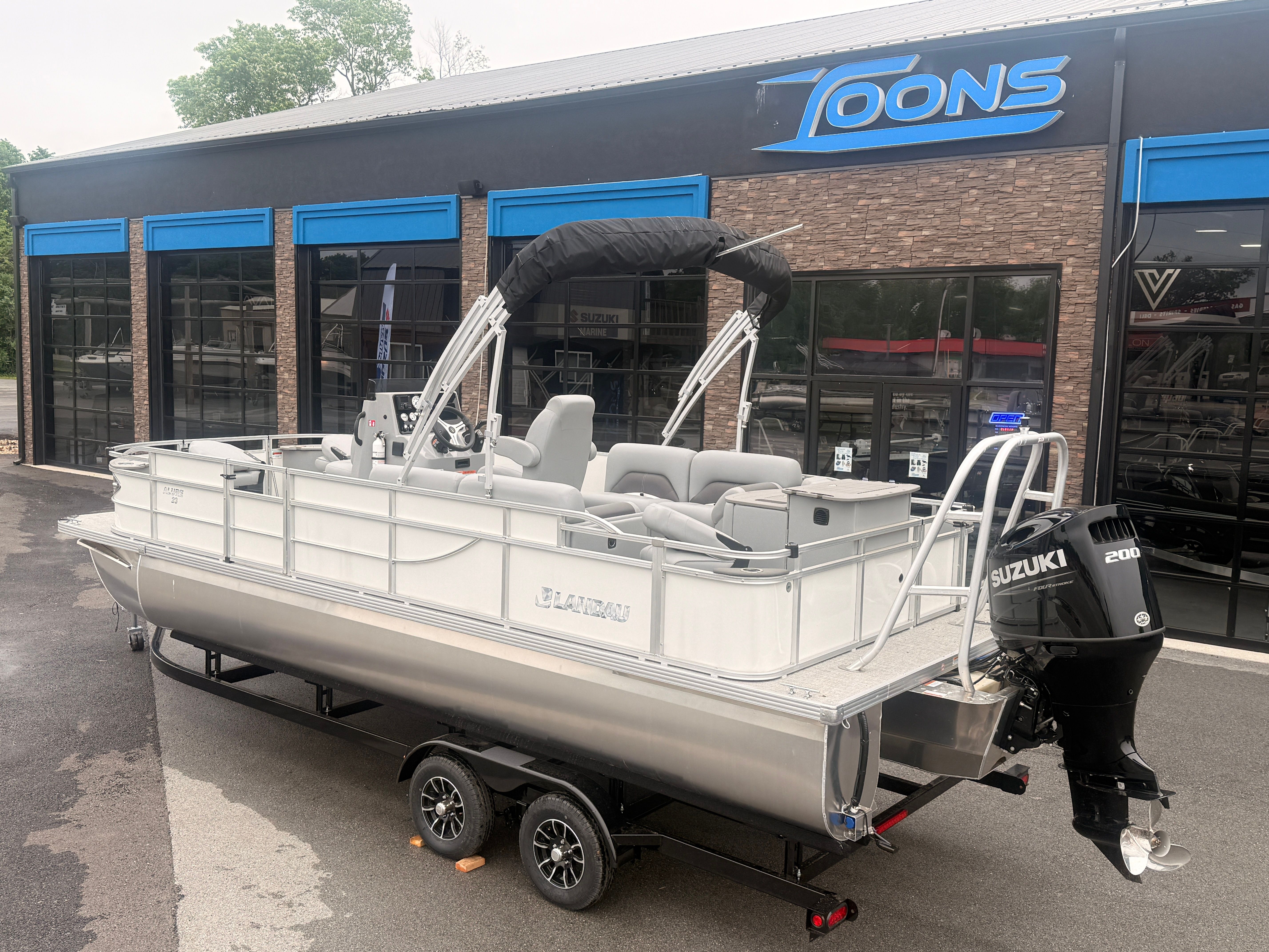 2026 Landau Alure 23CC Fish boat in front of a store.