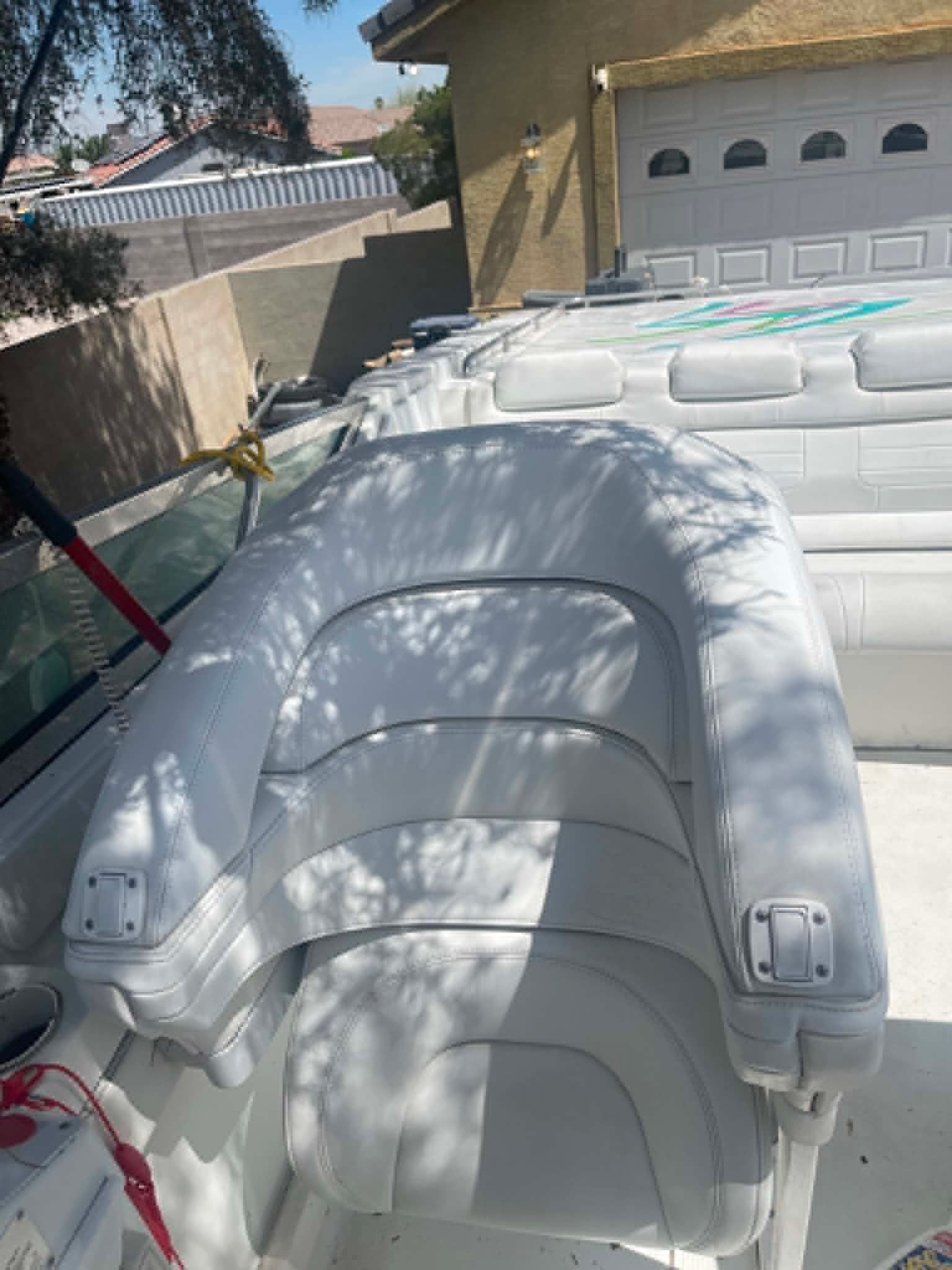 The image shows a boat cockpit with white cushioned seats and a steering wheel.