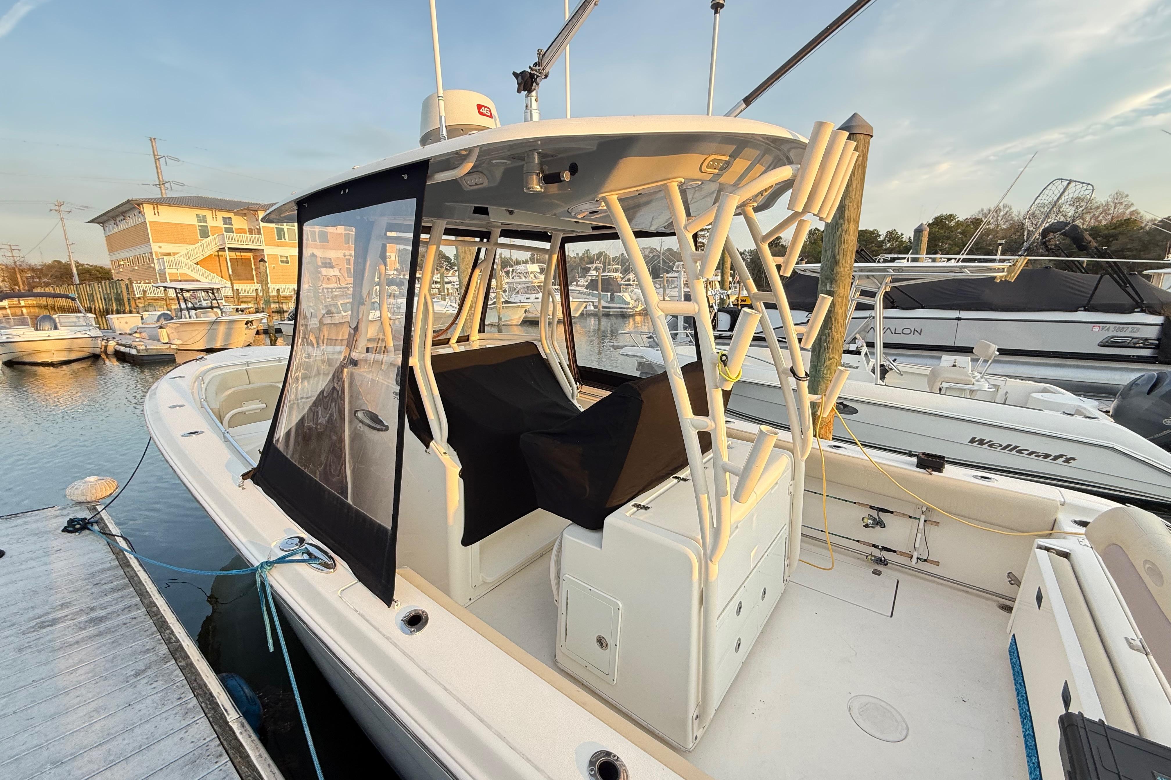 2016 Cobia 296 Center Console boat docked at marina, featuring enclosed helm area.