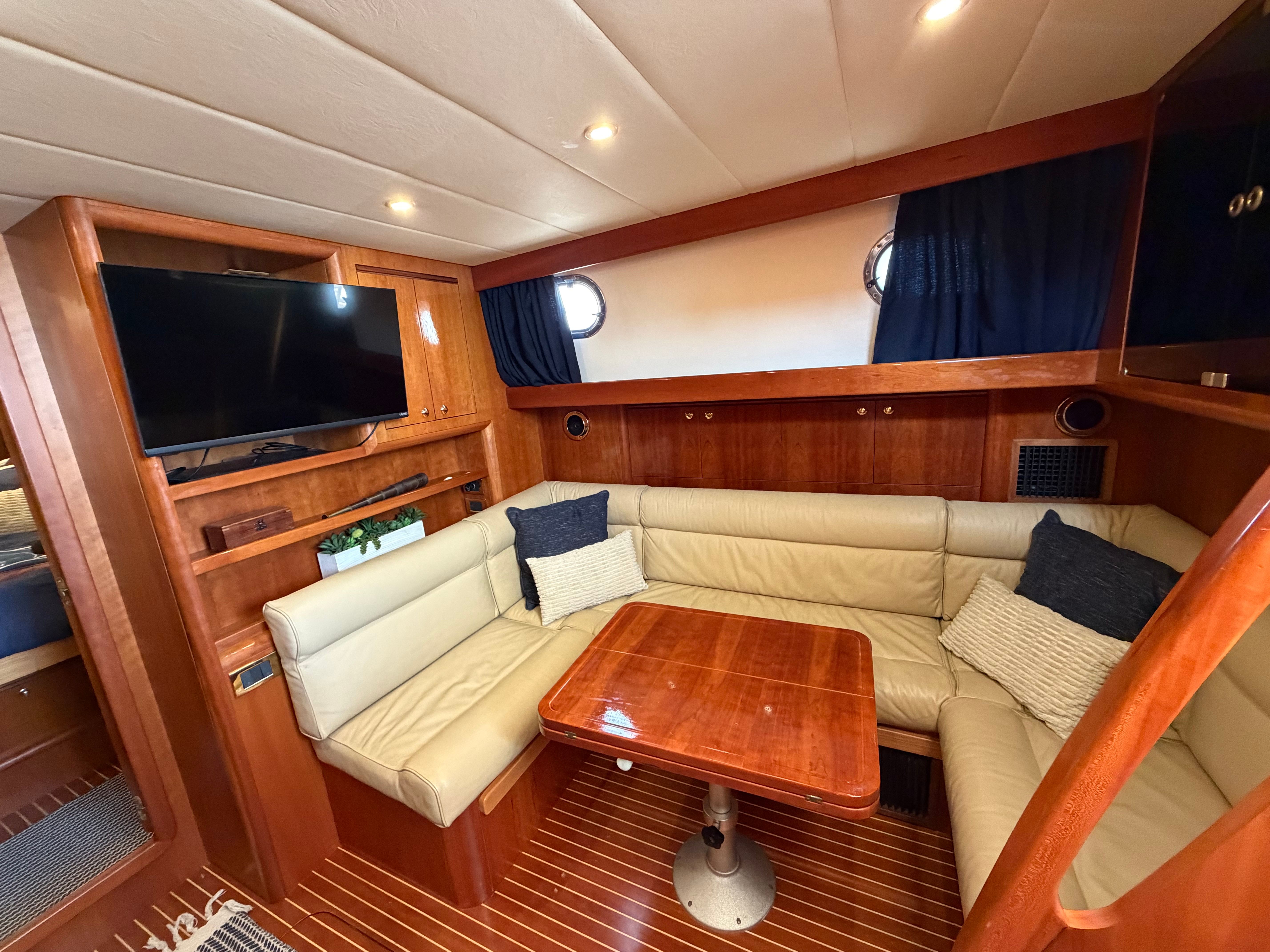 Interior of a 2003 Apreamare 11 with a cozy seating area and wooden table.