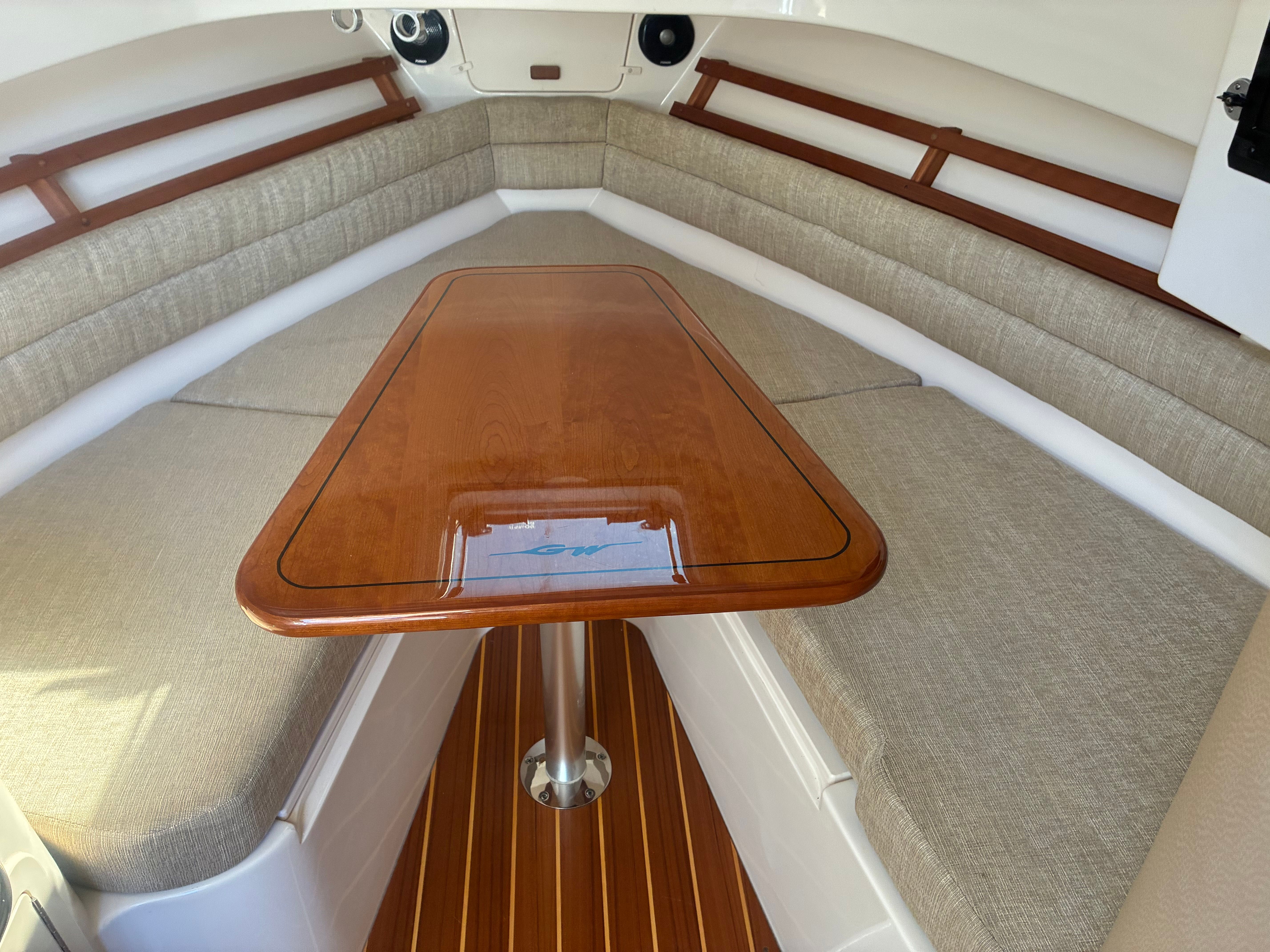 Interior of the Grady-White Marlin 300 with a wooden table and cushioned benches.