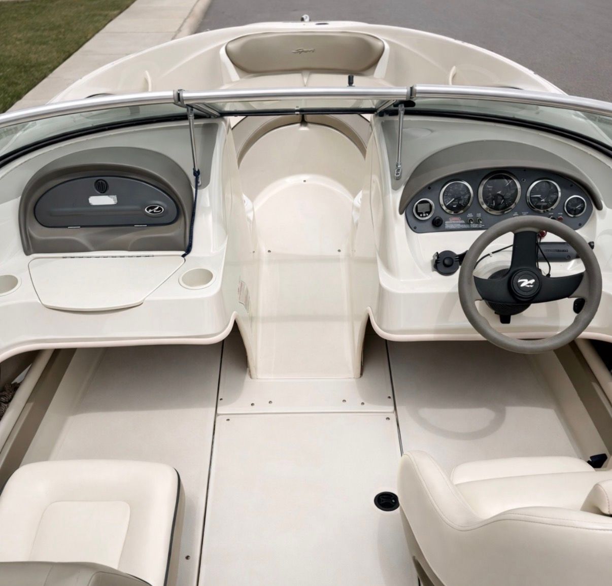 Interior of a 2005 Sea Ray 200 Sport boat, beige upholstery.