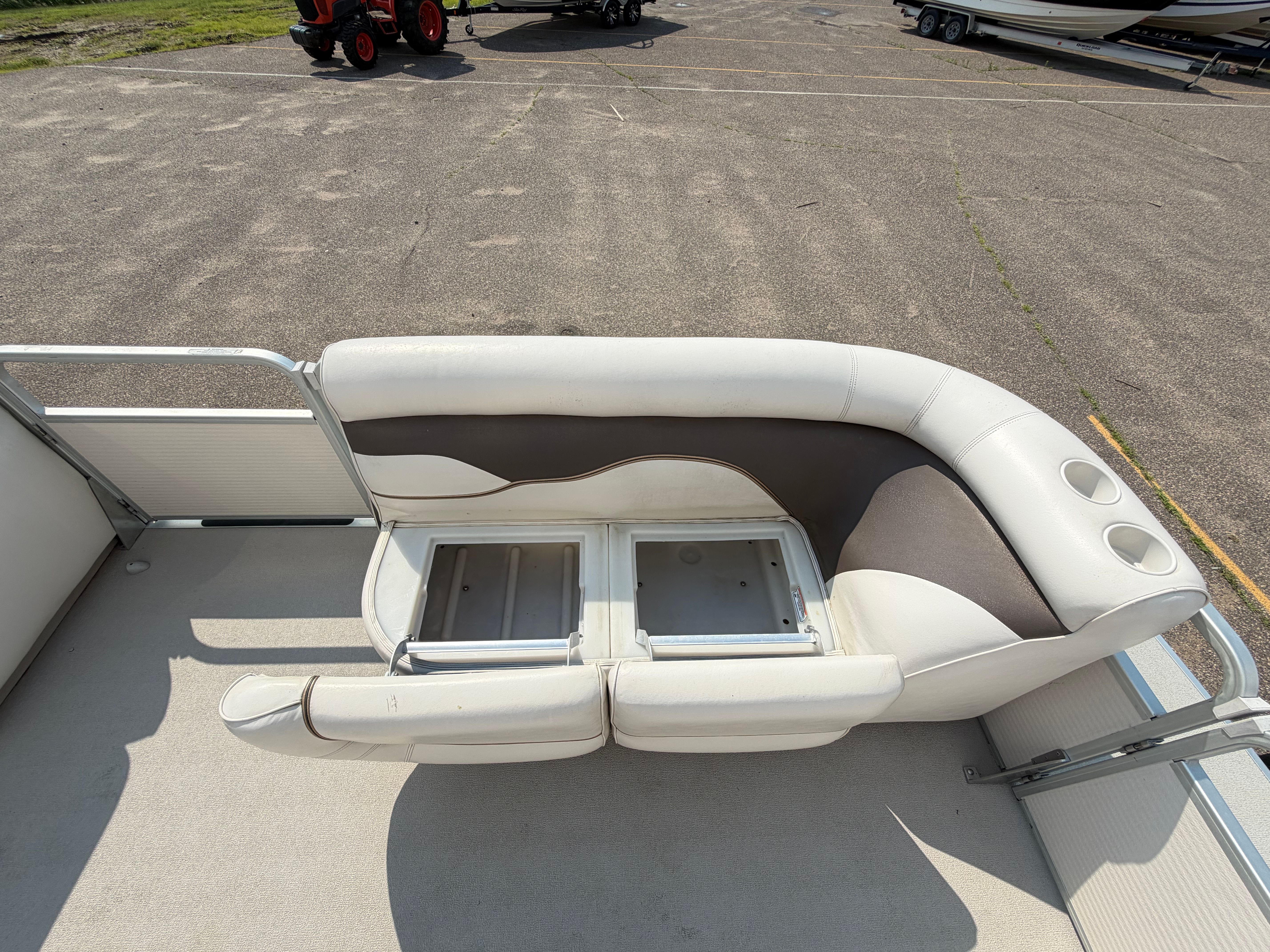 The image shows the seating area of a 2007 Premier 225 Sunsation pontoon boat with white upholstery.