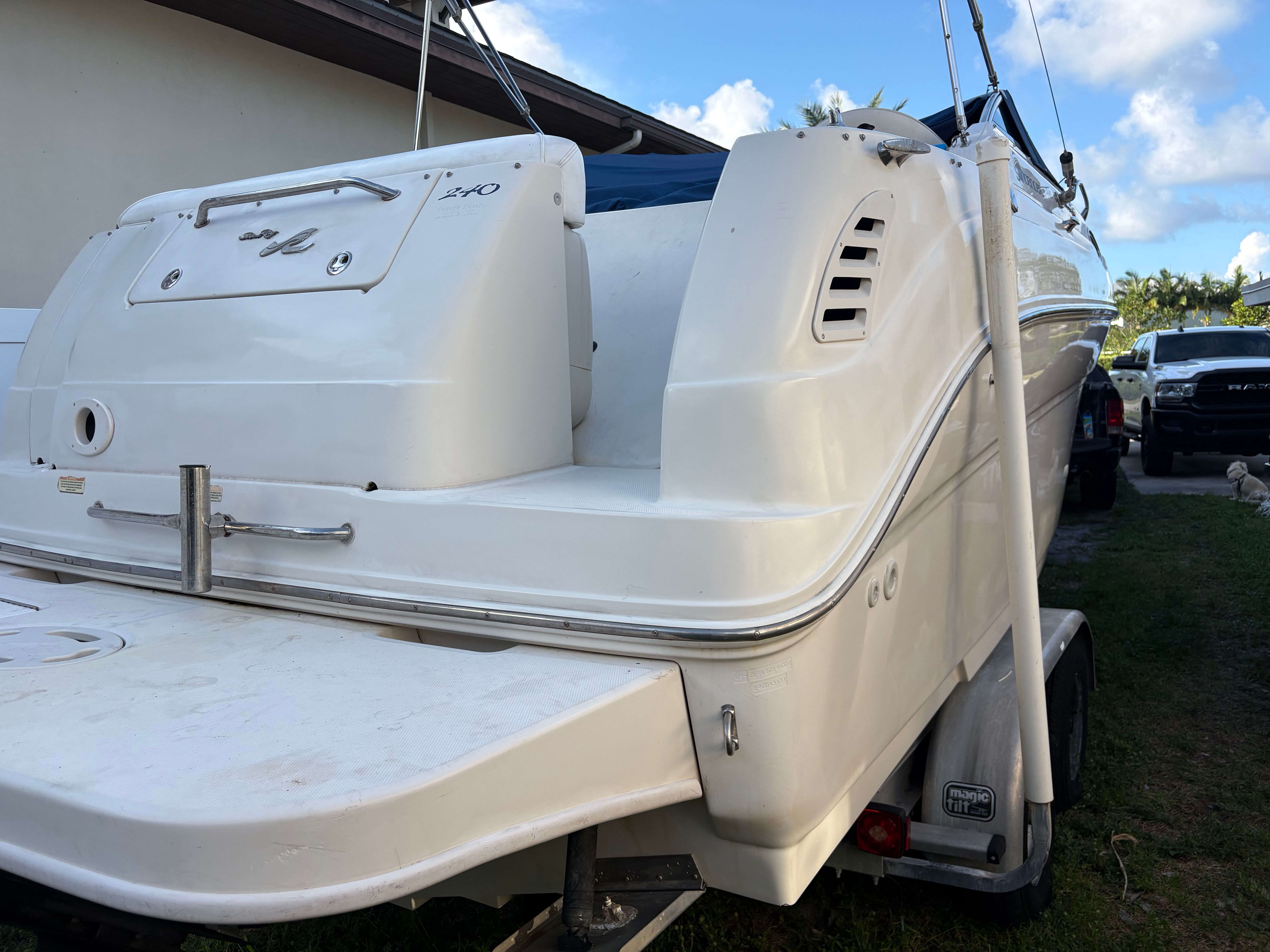 A 2001 Sea Ray 240 Sundancer on a trailer. It features a sleek, white design.
