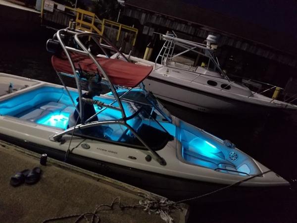 2005 Centurion Avalanche C4 boat with blue interior lights docked at night.