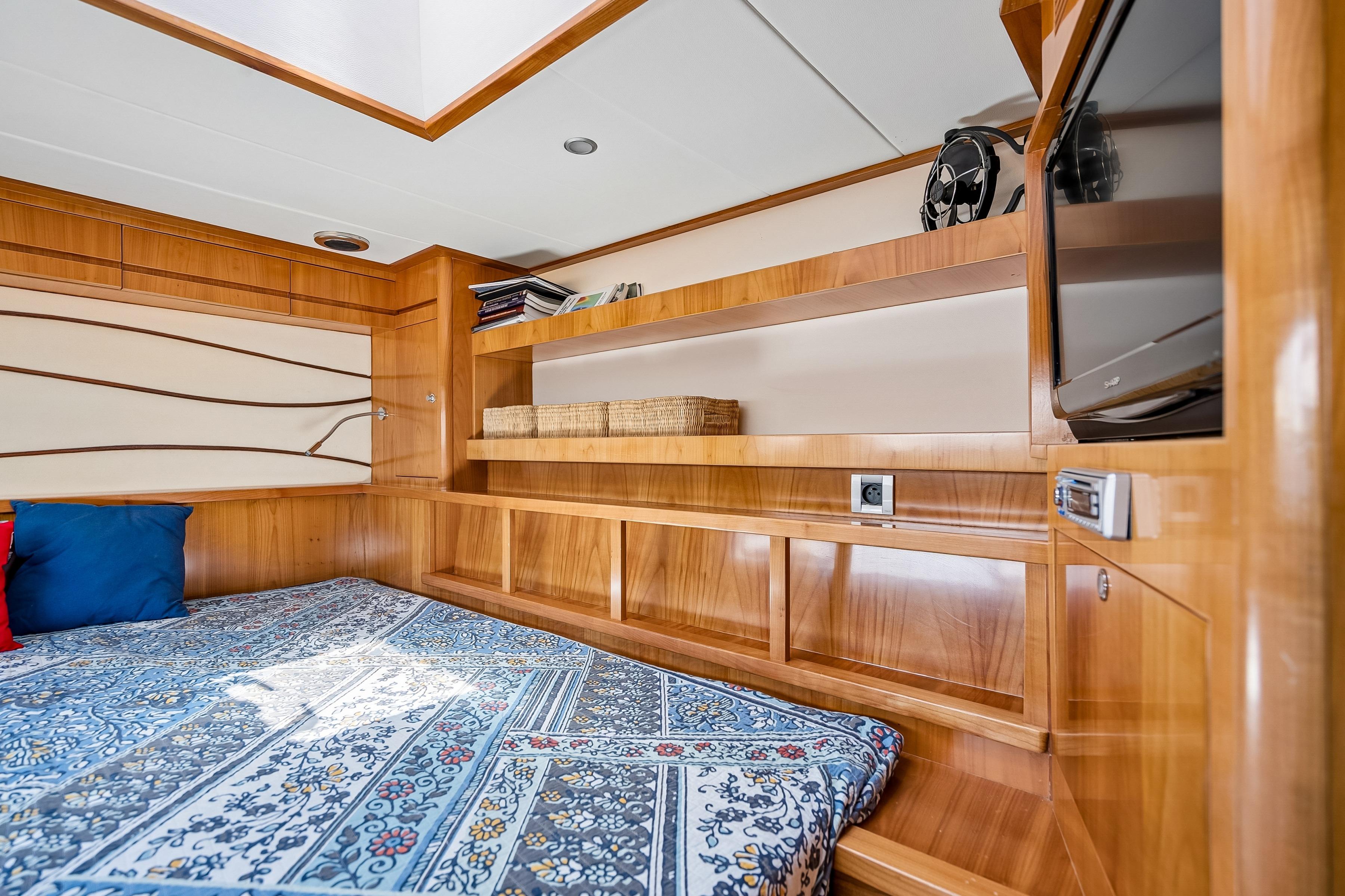 Luxurious Catana 65 yacht interior, featuring elegant wood paneling and a cozy bed, 2009 model.