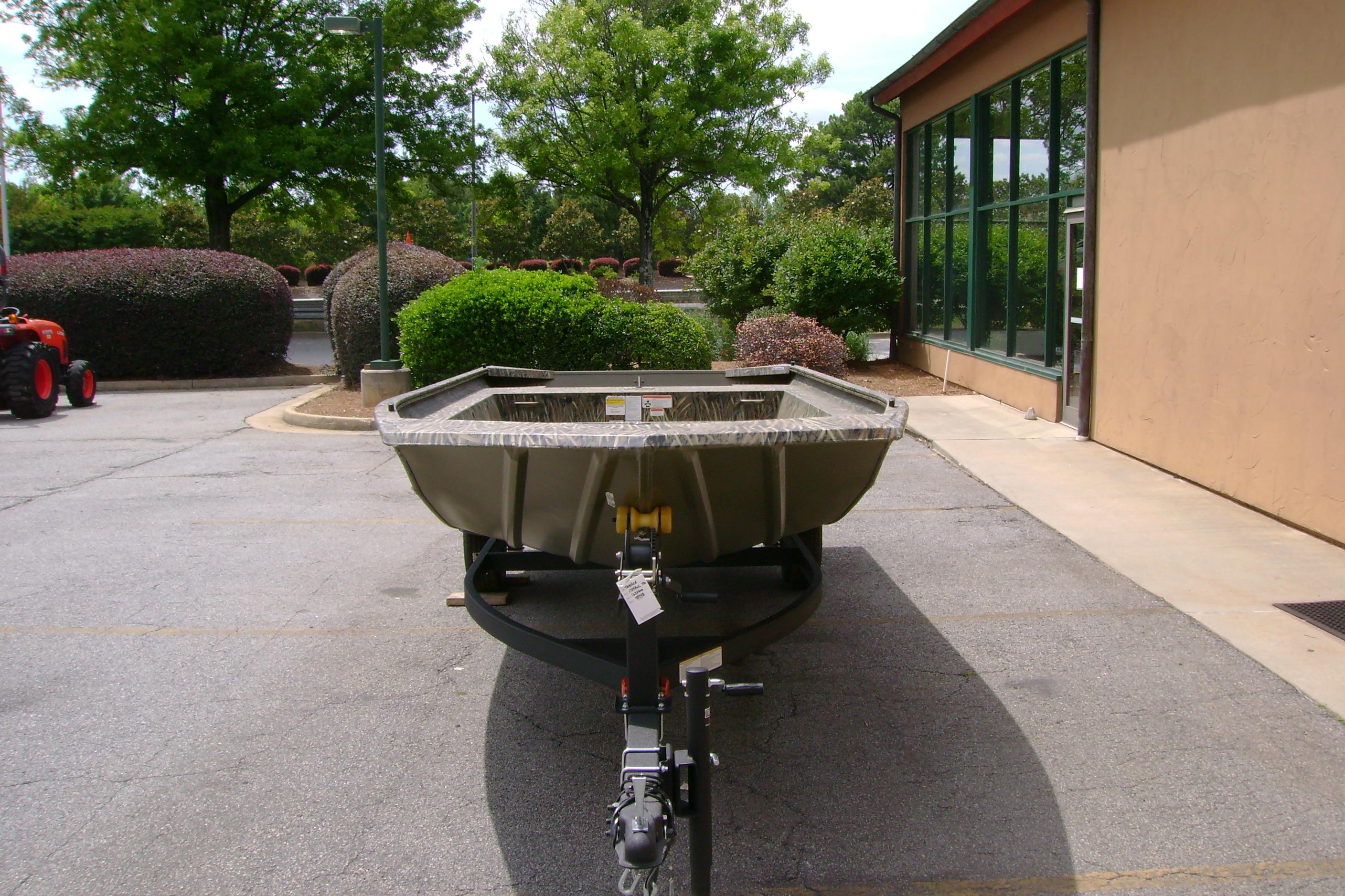 2026 Tracker Grizzly 1754 Utility boat parked outdoors near a building.