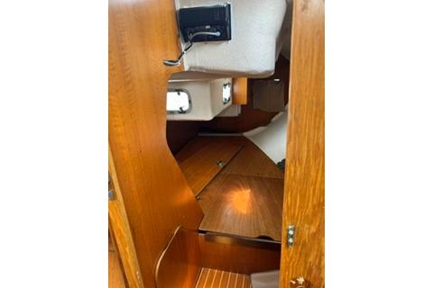 Interior cabin of a 1986 Beneteau First 305 sailboat, featuring wooden finishes and compact design.