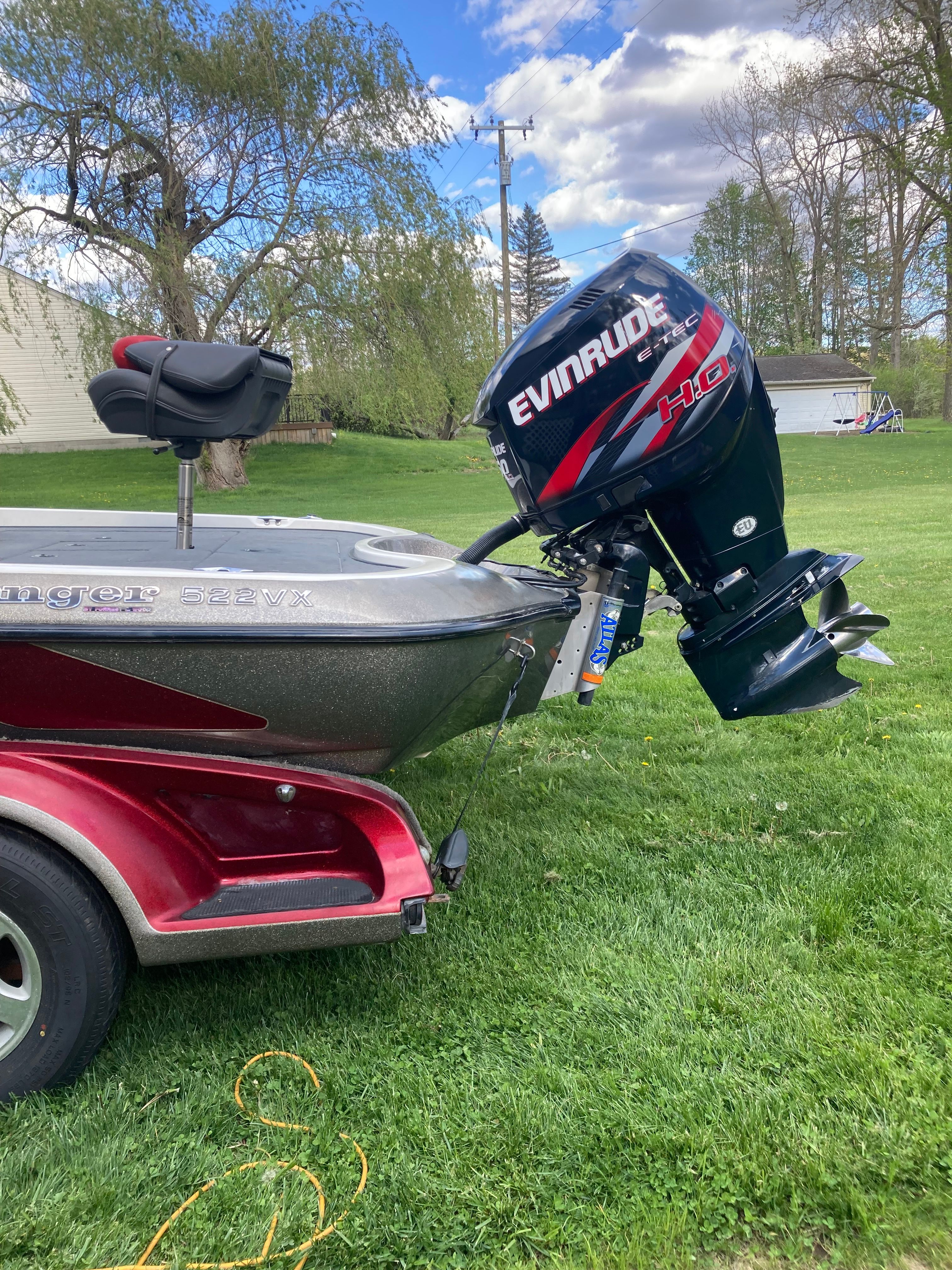 A 2002 Ranger 522DVX Comanche boat with an Evinrude motor is on a grassy lawn.