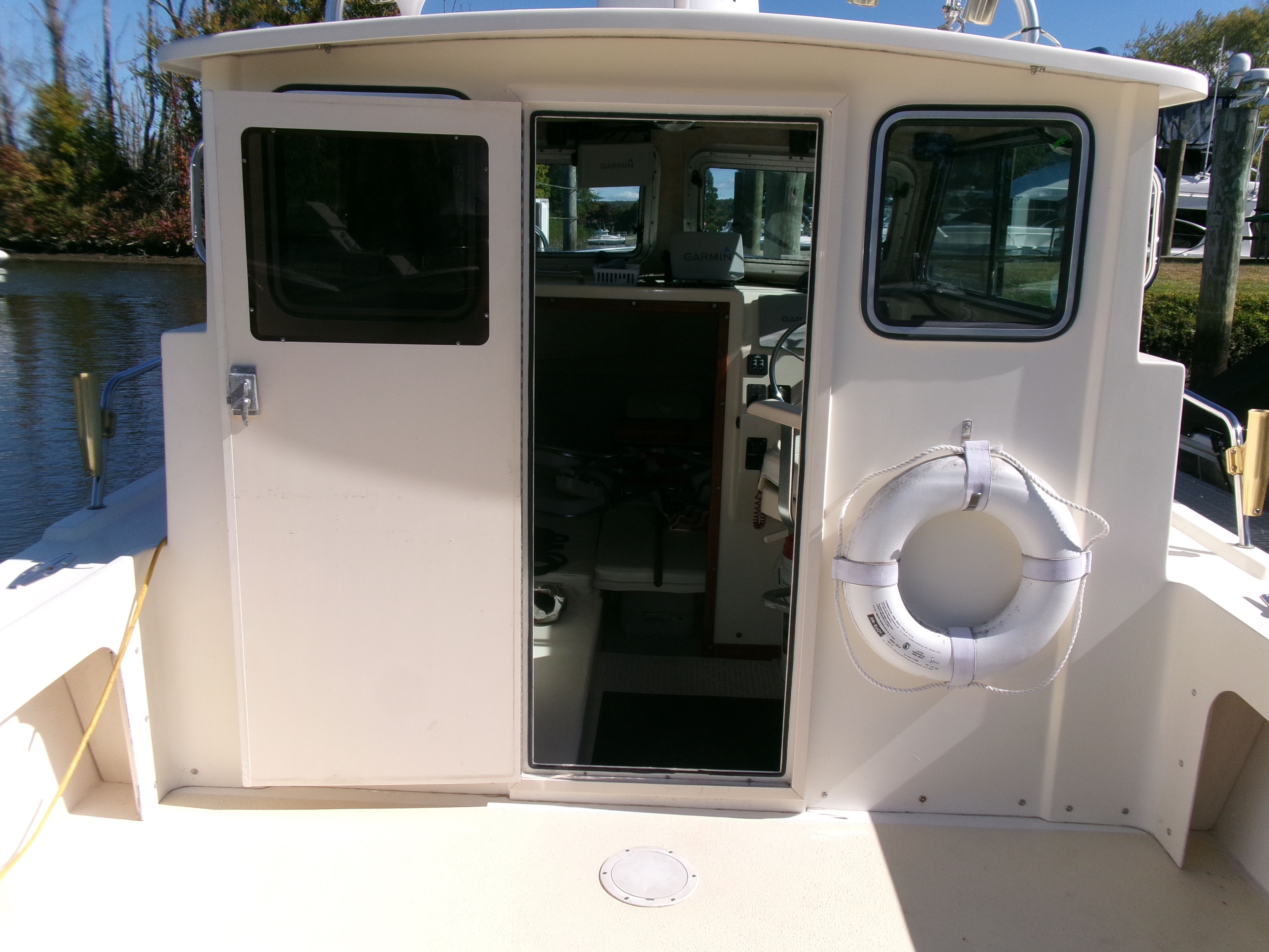 The 2007 Parker 2520 XL Sport Cabin features an open cabin door with a life ring on the side.